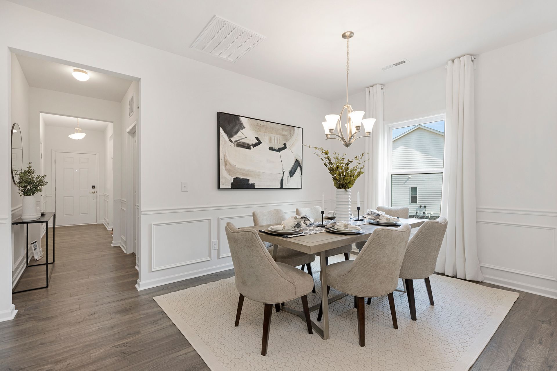 A dining room with a table and chairs and a chandelier.