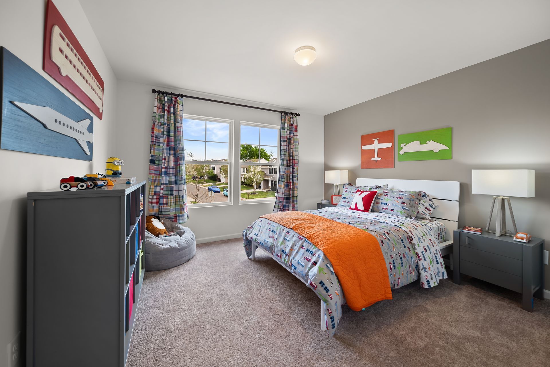 A bedroom with a bed , dresser , nightstand , and window.