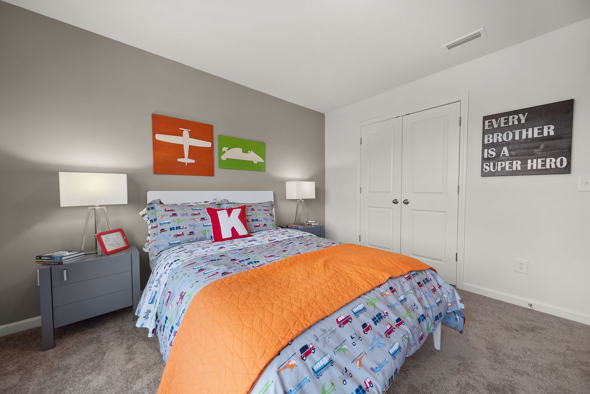 A bedroom with a bed and a sign that says every brother is a super hero