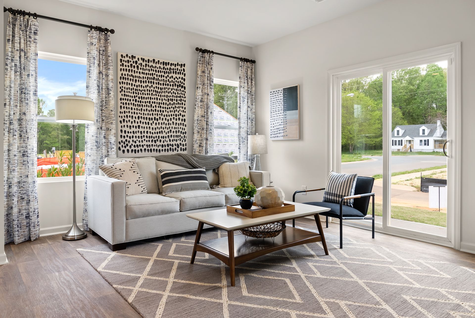A living room with a couch , coffee table , chairs and sliding glass doors.