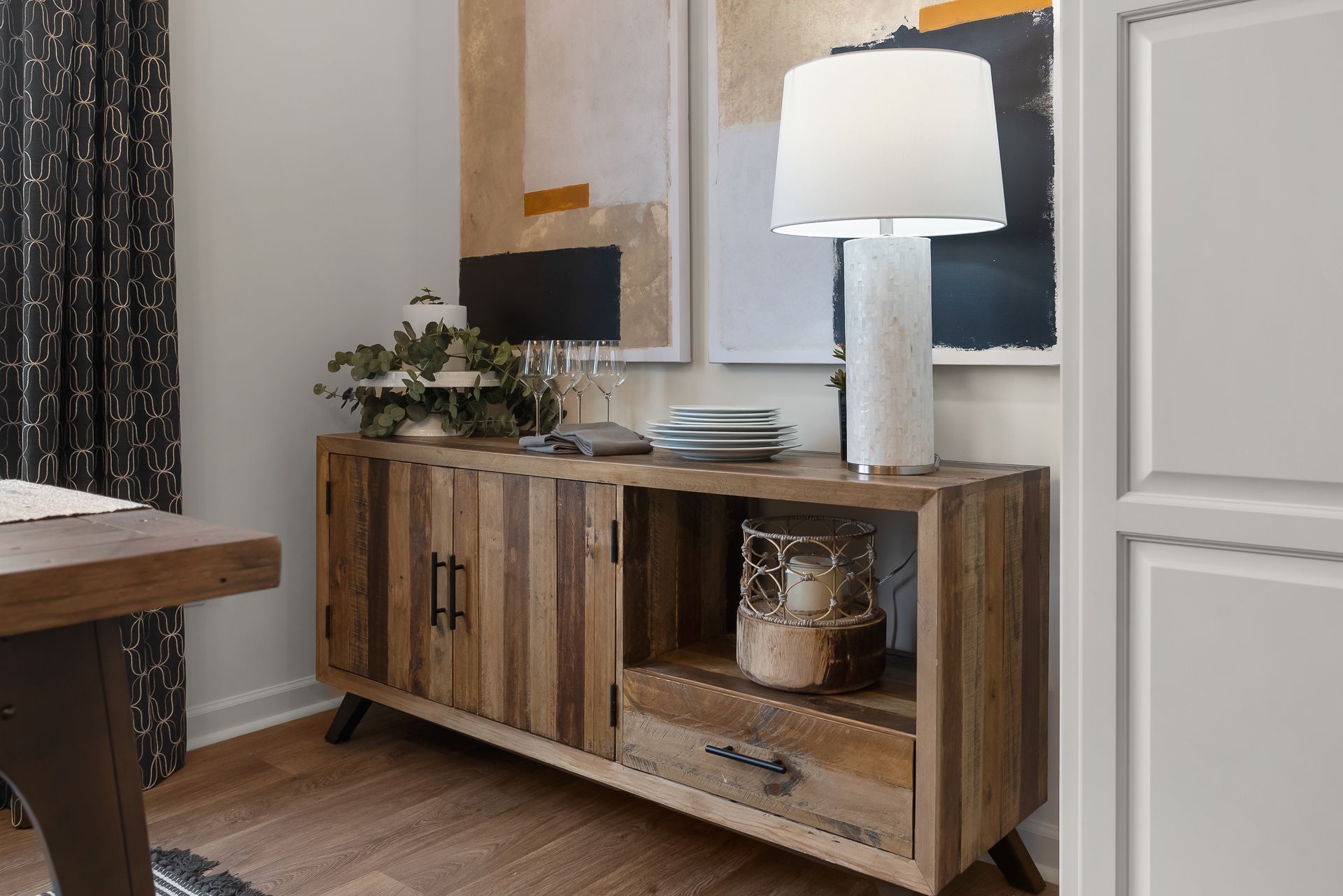 A wooden dresser with a lamp on top of it in a dining room.