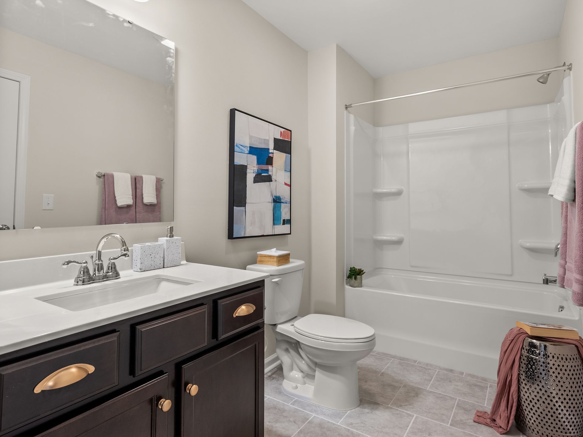 A bathroom with a sink , toilet , bathtub and mirror.