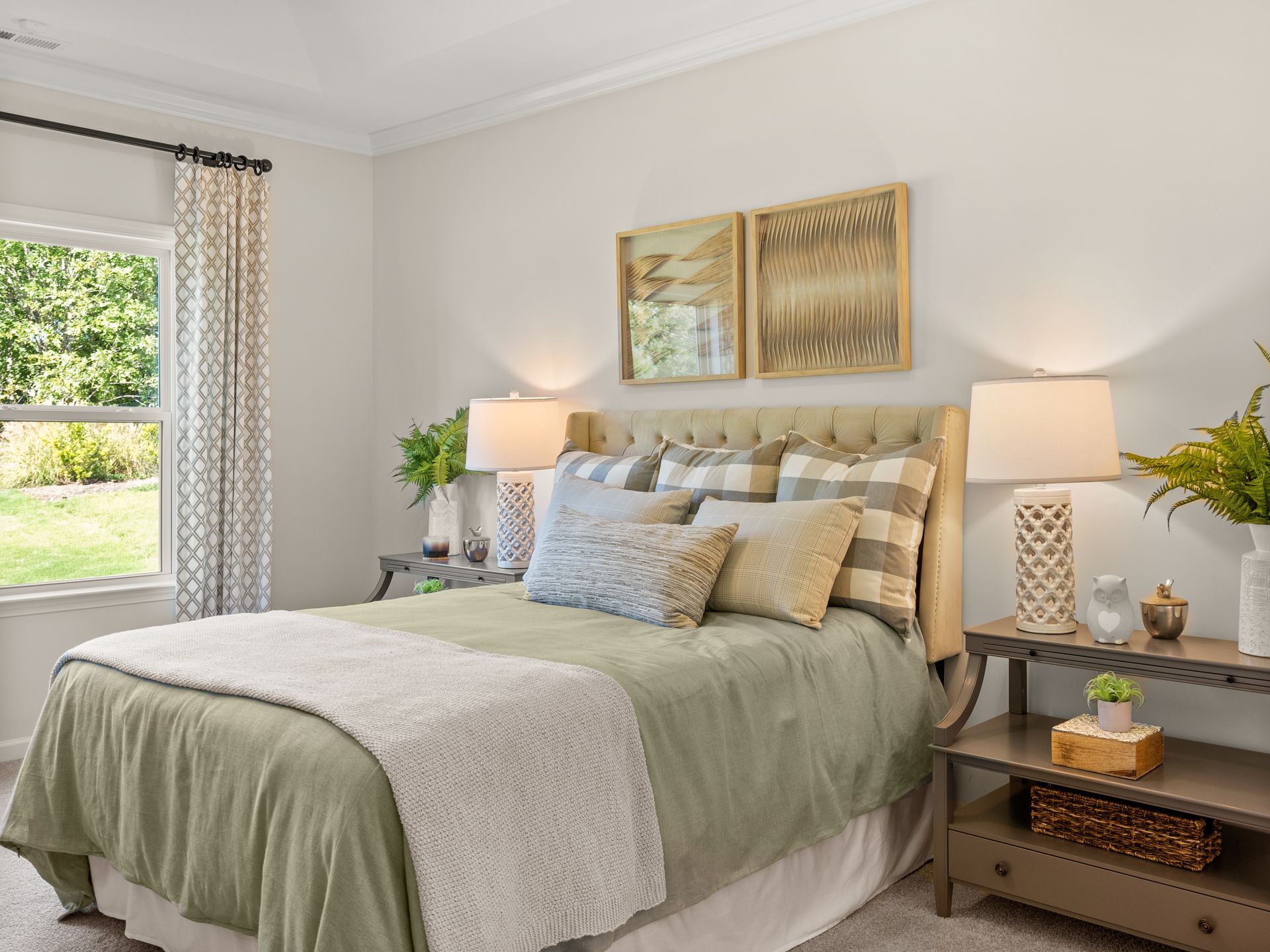 A bedroom with a bed , lamps , nightstands and a window.