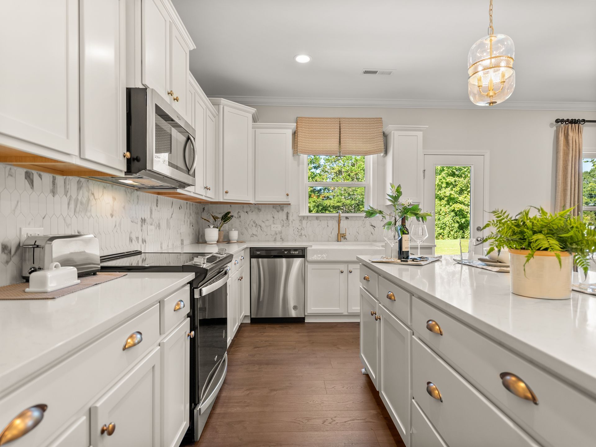 A kitchen with white cabinets , stainless steel appliances , and a large island.