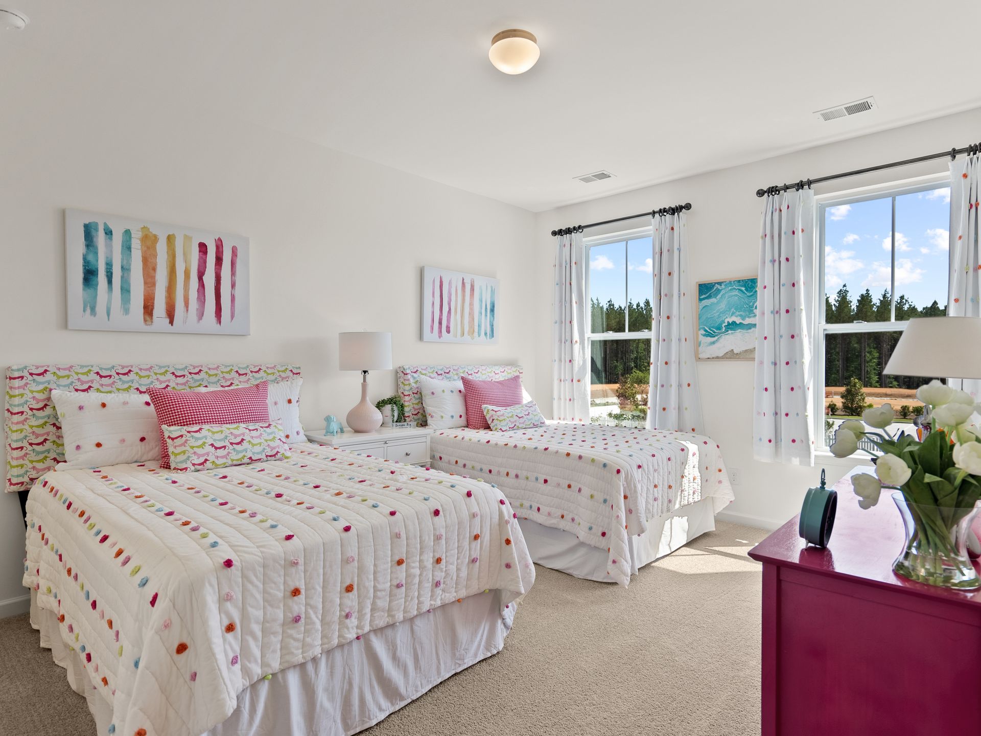 A bedroom with two beds and a pink dresser