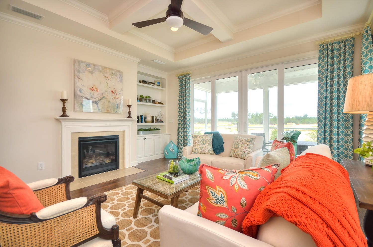 A living room with a fireplace and a ceiling fan.