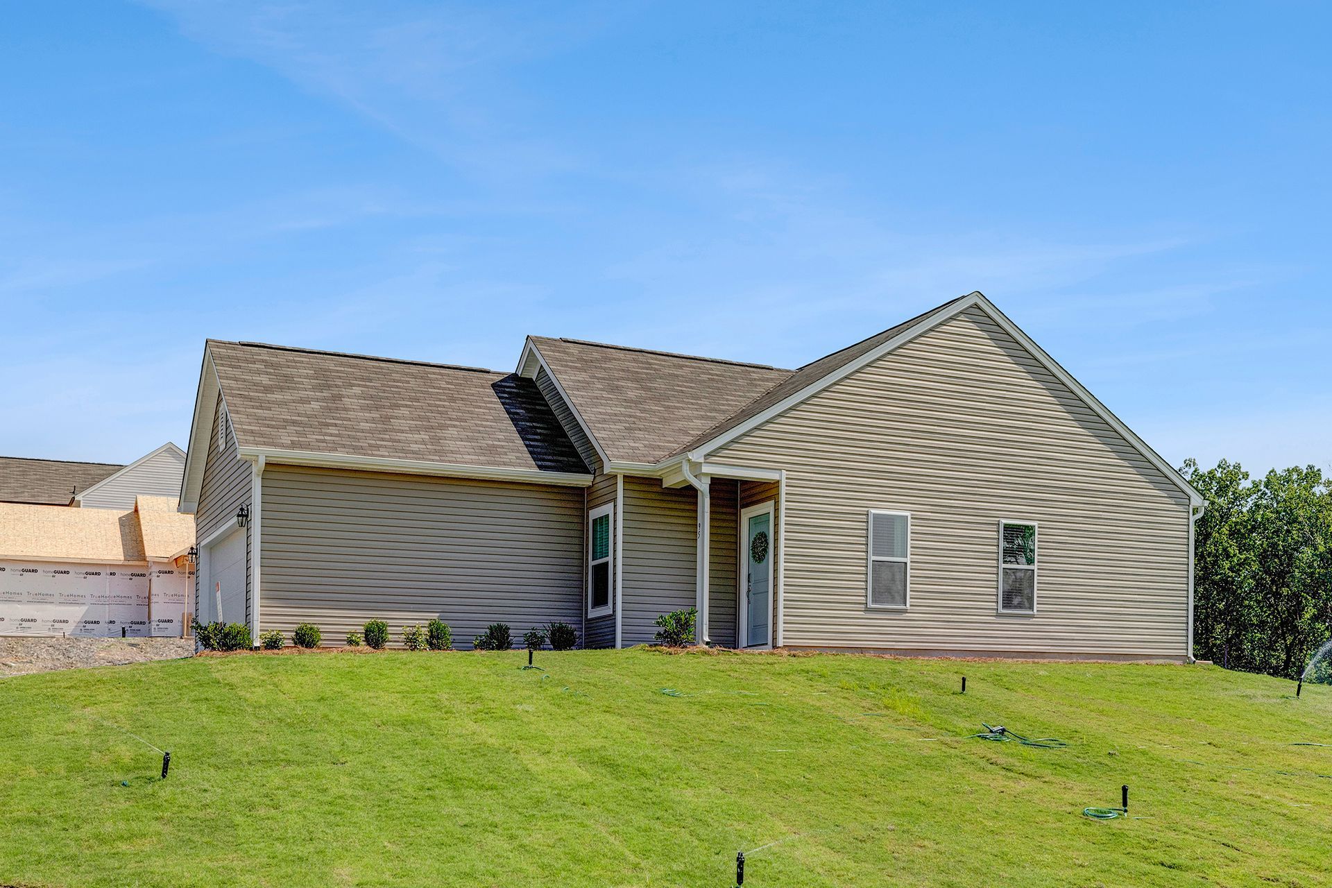 A house is sitting on top of a lush green hill.