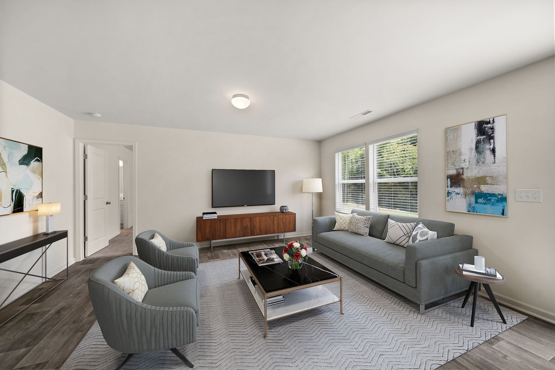 A living room with a couch , chairs , coffee table and television.