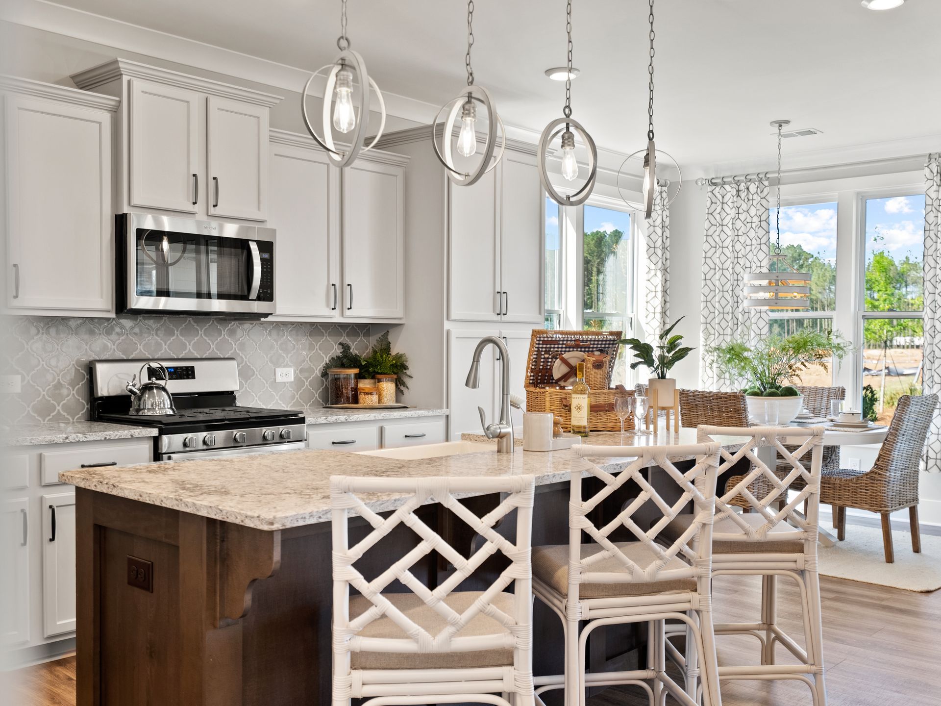 A kitchen with white cabinets , granite counter tops , stainless steel appliances , and a large island.