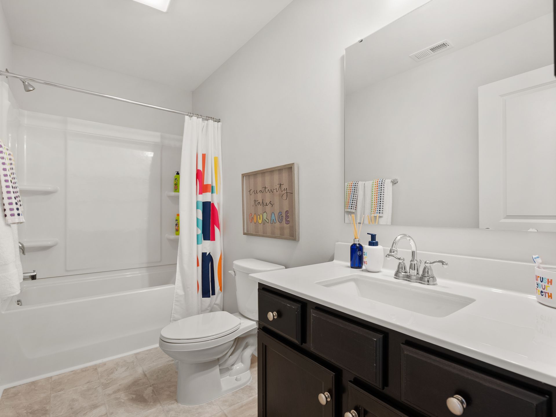 A bathroom with a toilet , sink , and bathtub.