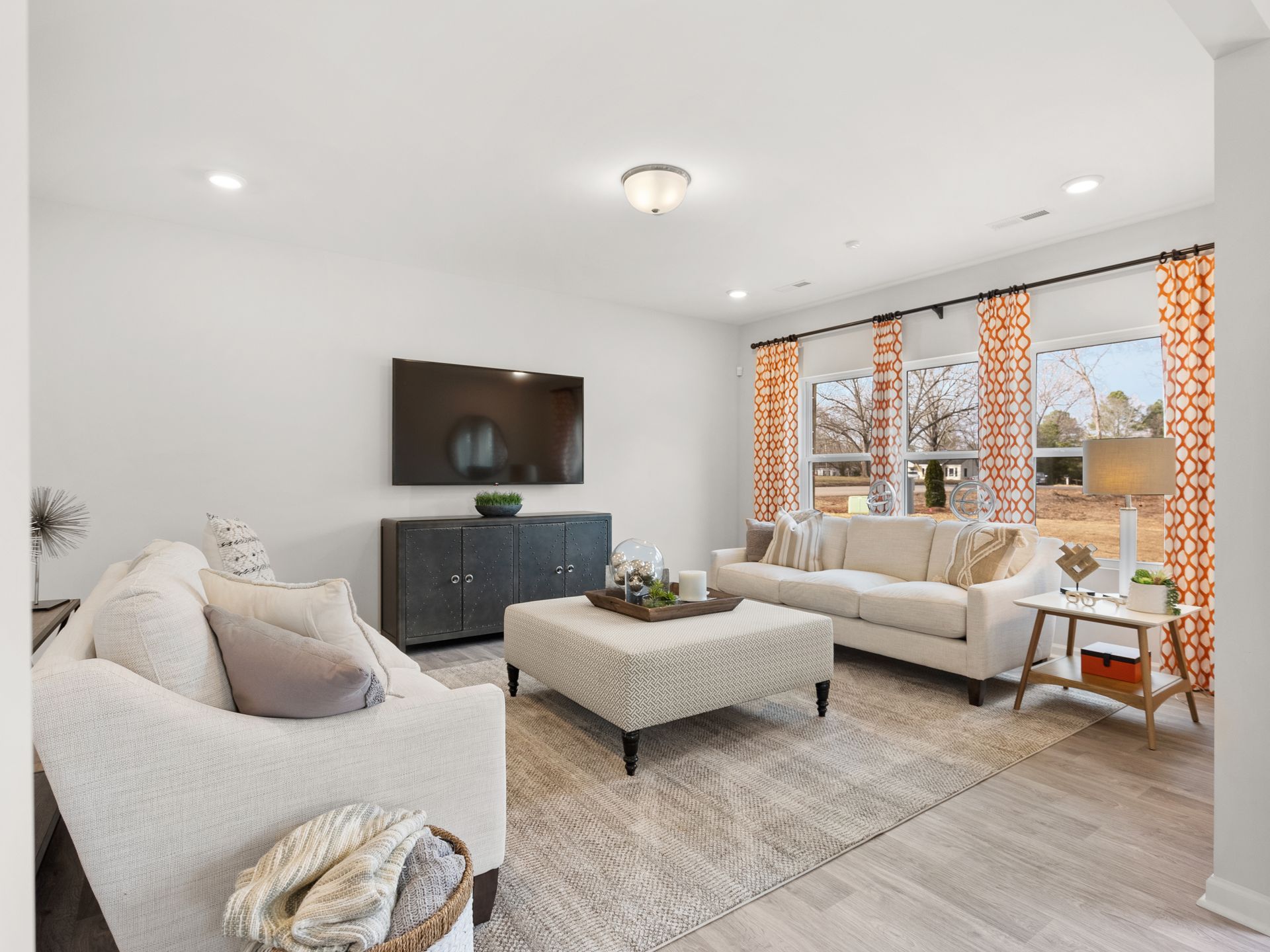 A living room with two couches , a coffee table , and a flat screen tv.