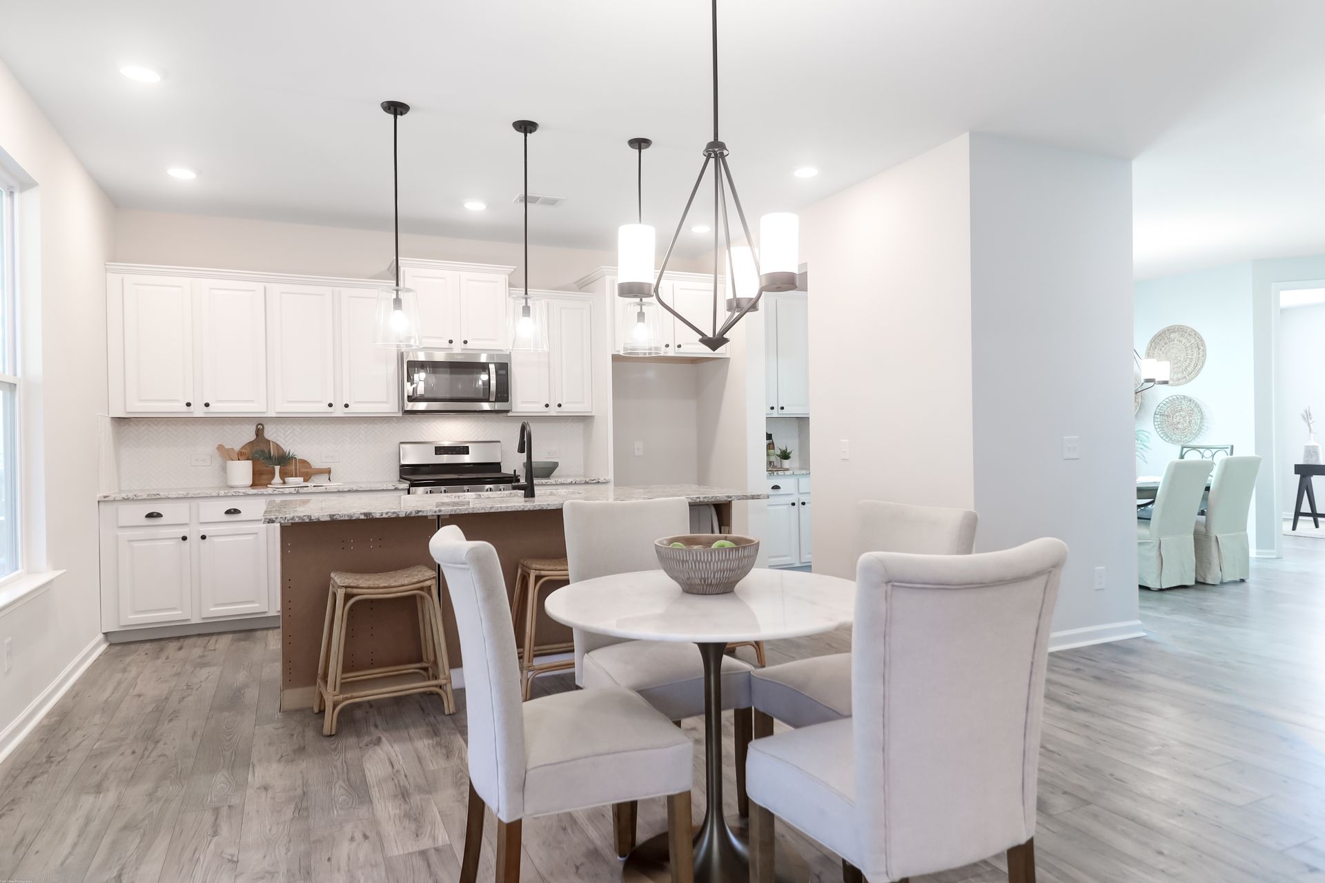 A kitchen and dining room in a house with a table and chairs.