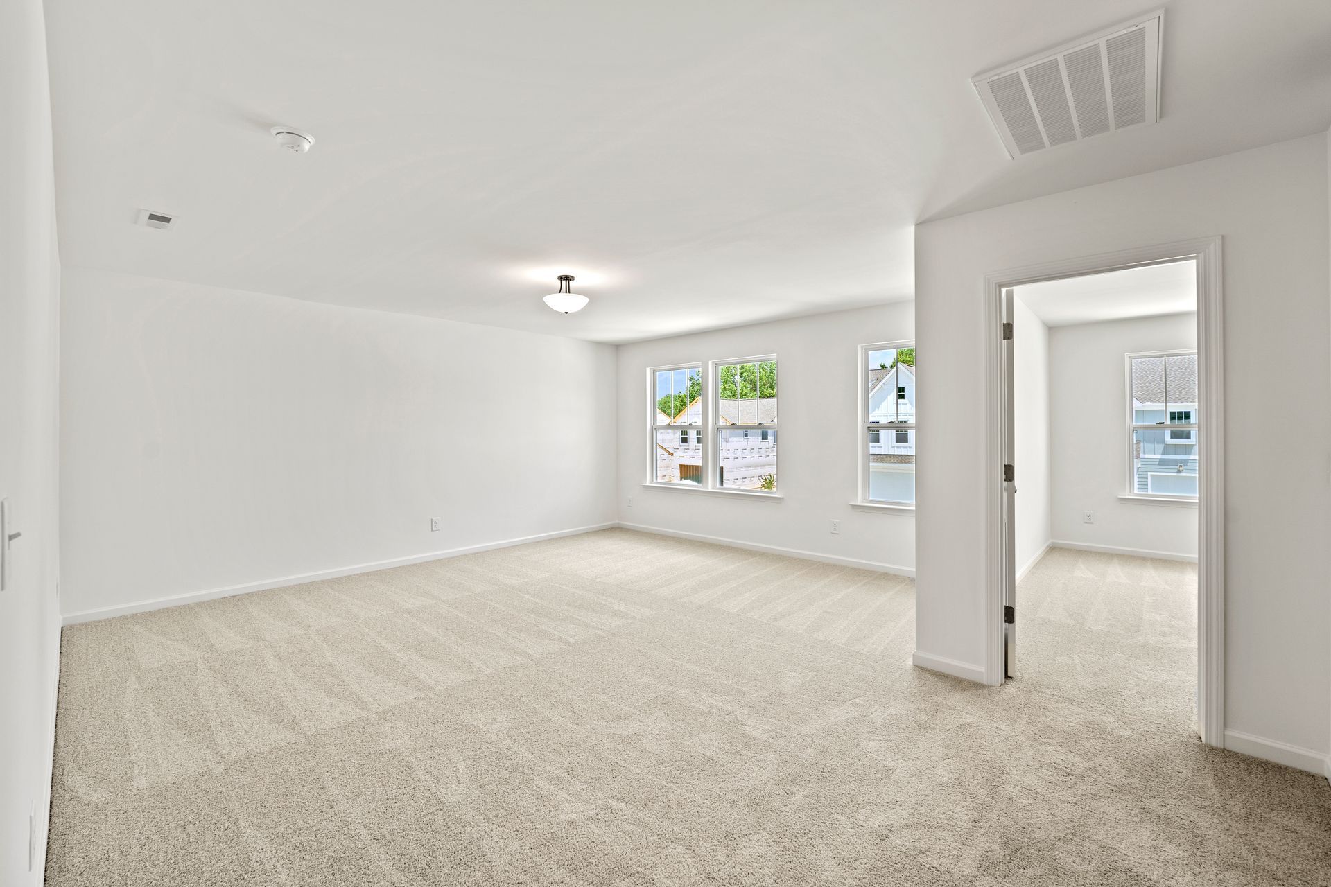 A large empty room with a carpeted floor and white walls.