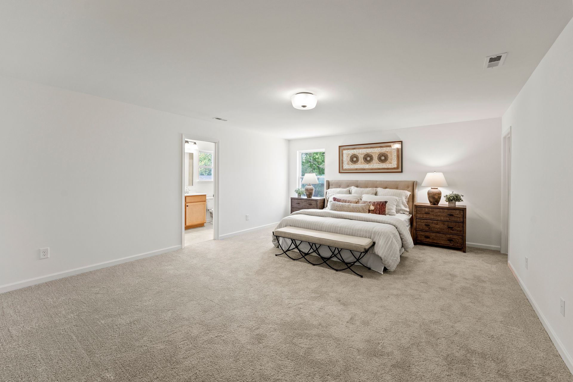 A bedroom with a bed , nightstand , and bench.