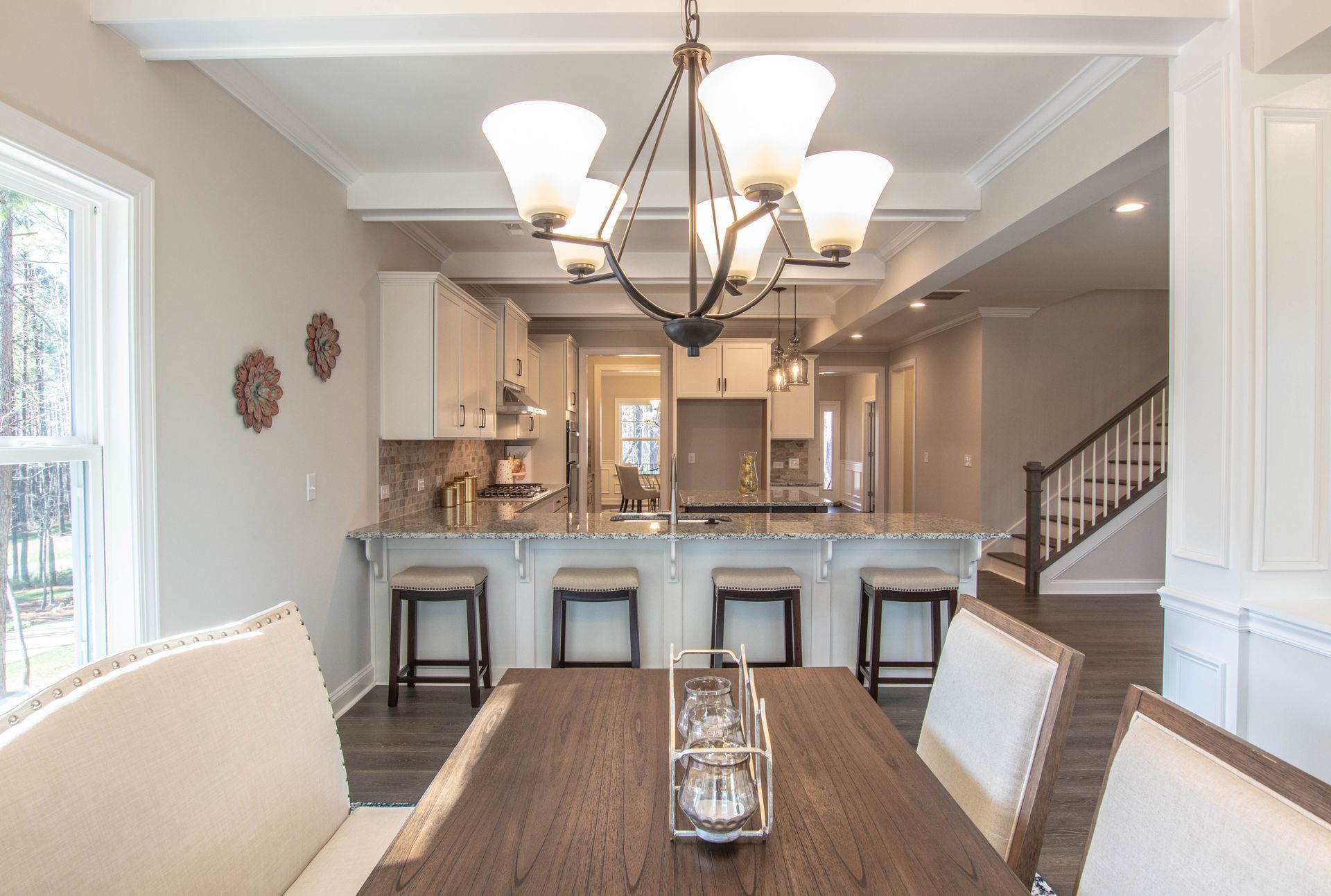 A dining room with a table and chairs and a chandelier hanging from the ceiling.