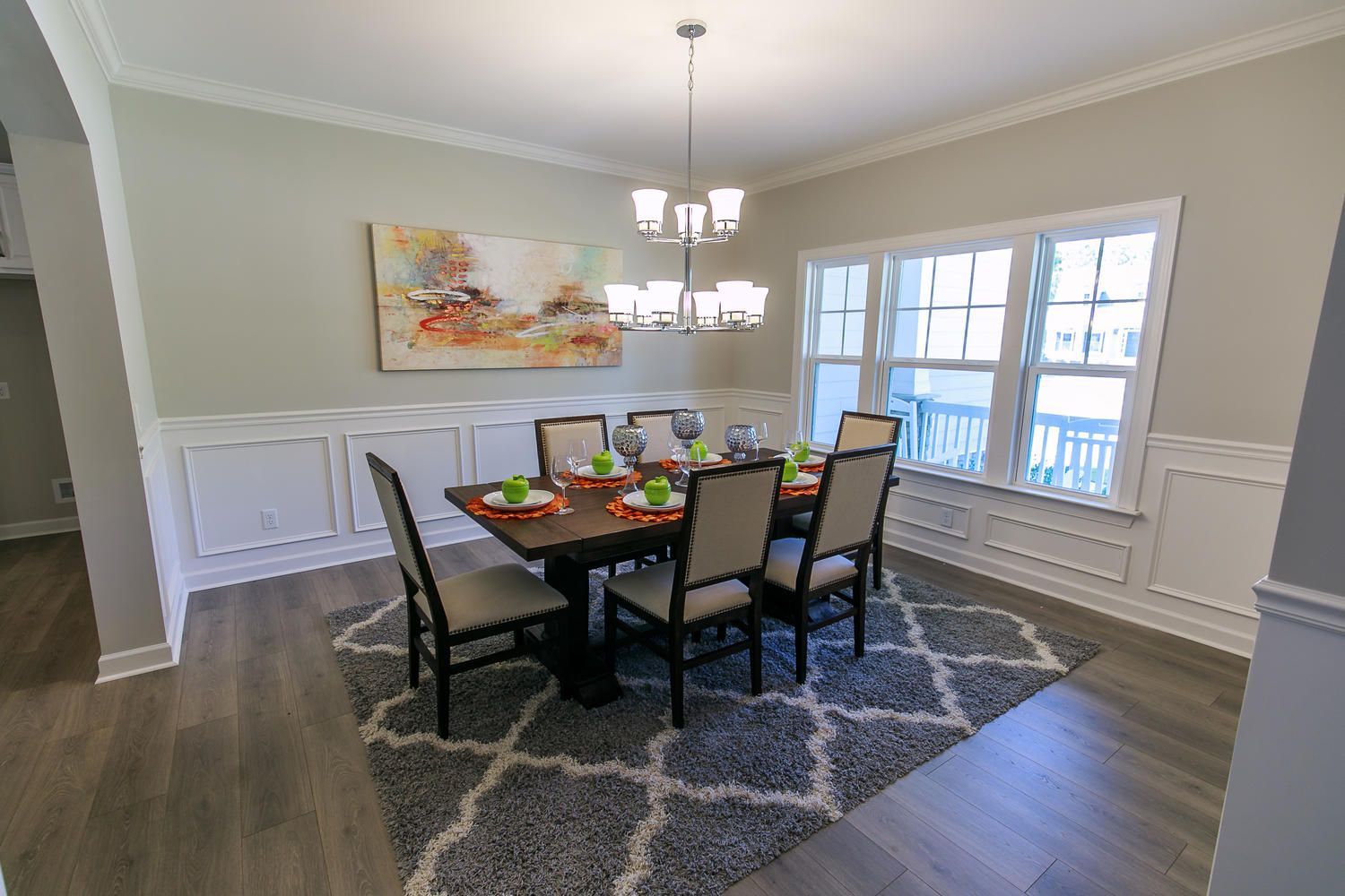 A dining room with a table and chairs and a rug.