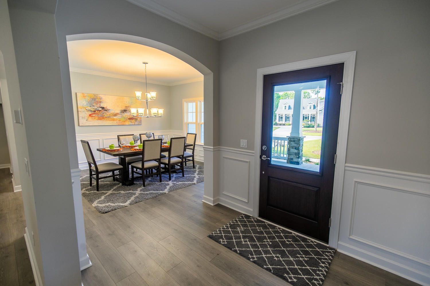 A hallway leading to a dining room with a table and chairs.