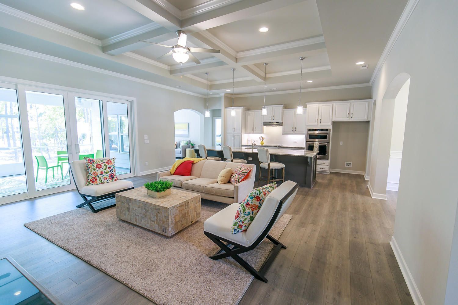 A living room with a couch , chairs and a coffee table in a house.