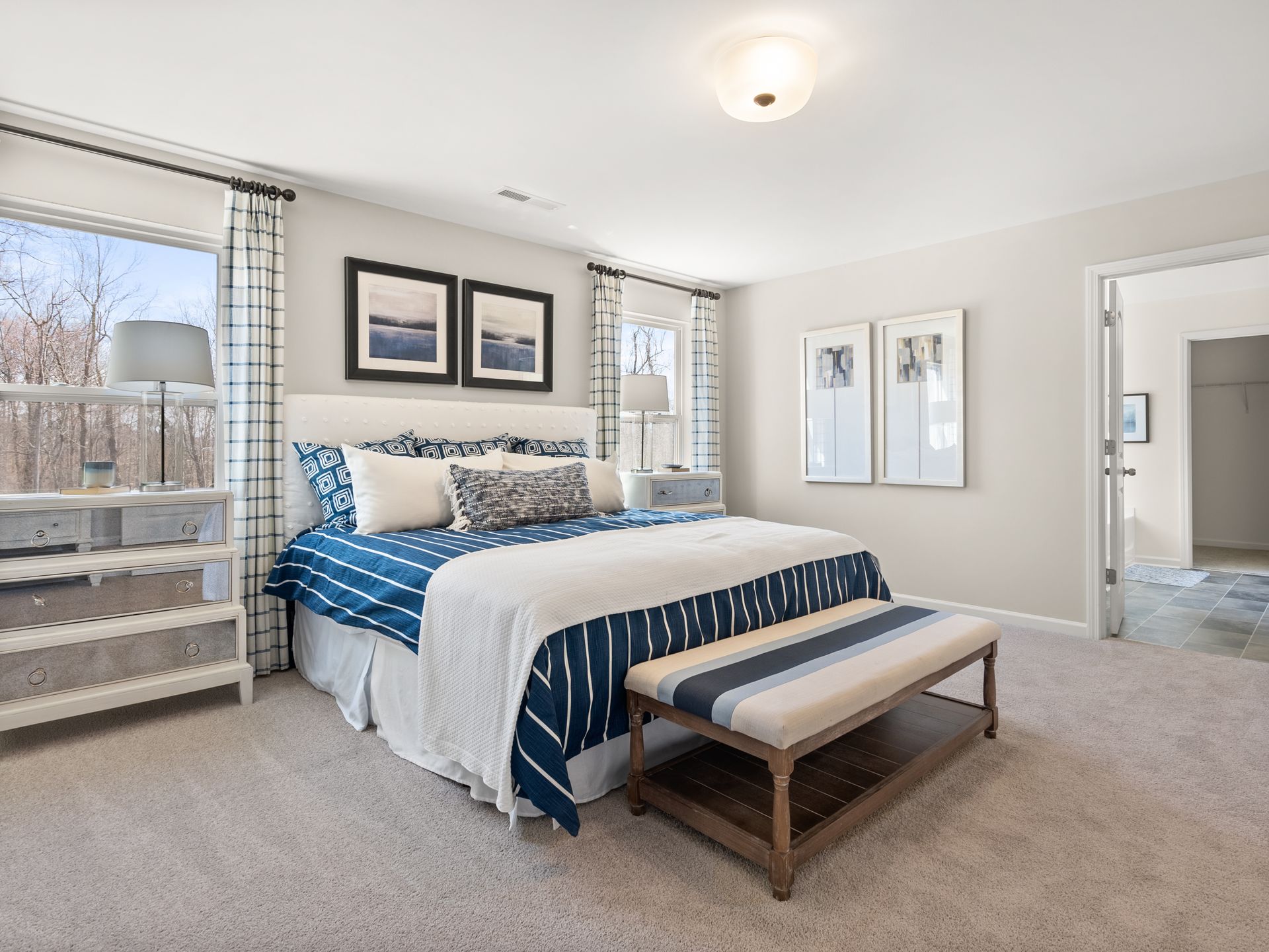 A bedroom with a king size bed and a bench.