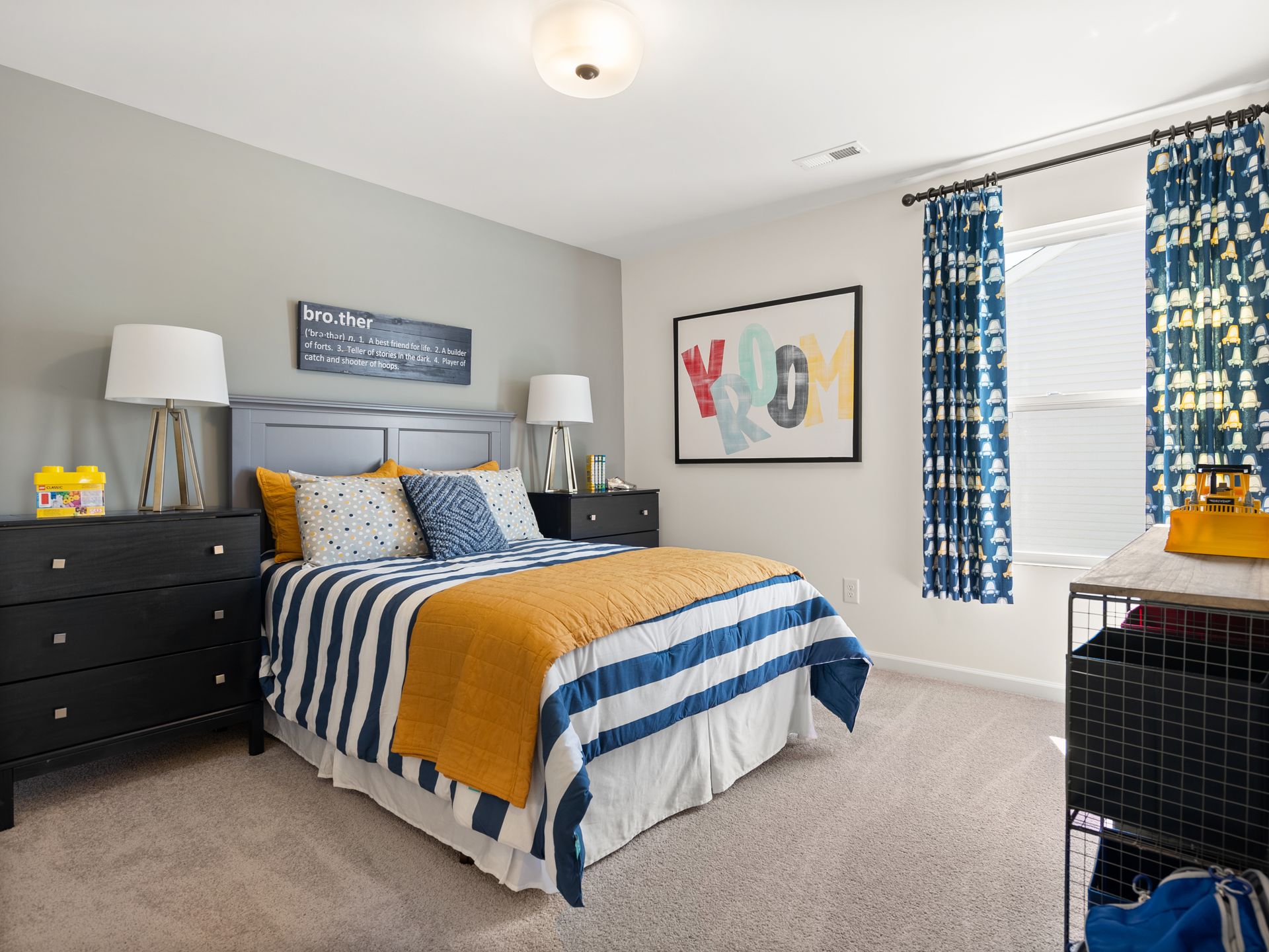 A bedroom with a bed , dresser , nightstand , and window.