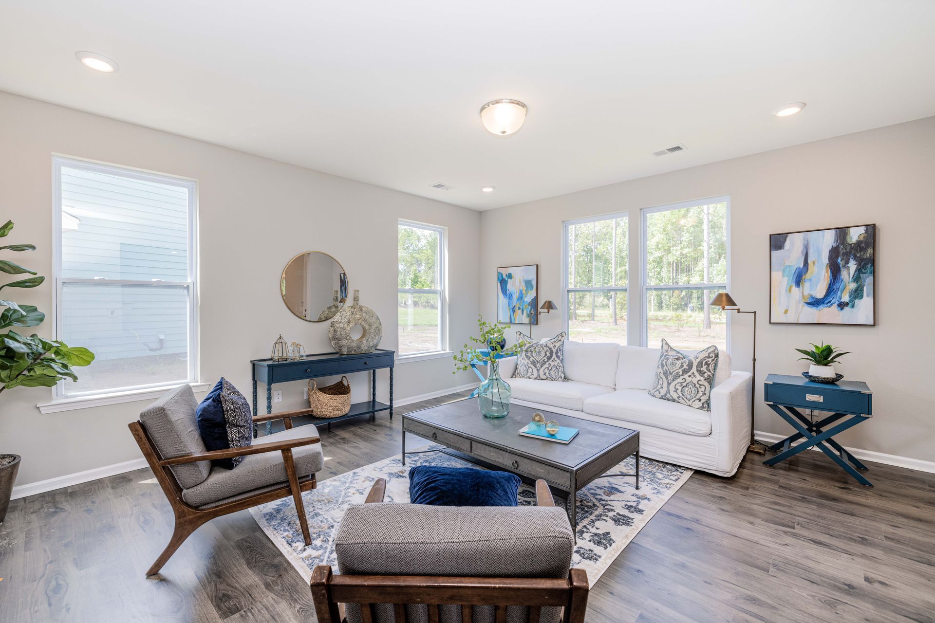 A living room with a couch , chairs , and a coffee table.