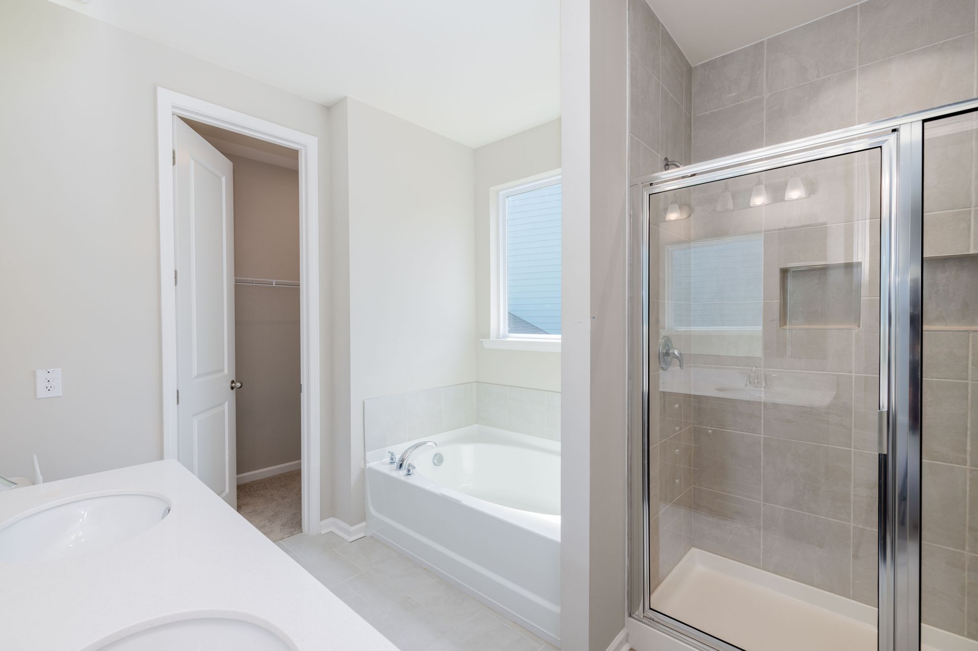A bathroom with a tub and a walk in closet.