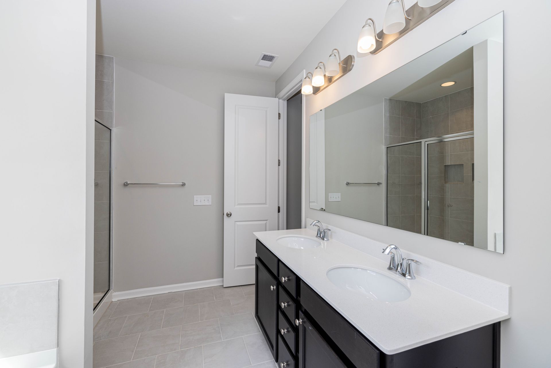 A bathroom with two sinks and a large mirror.