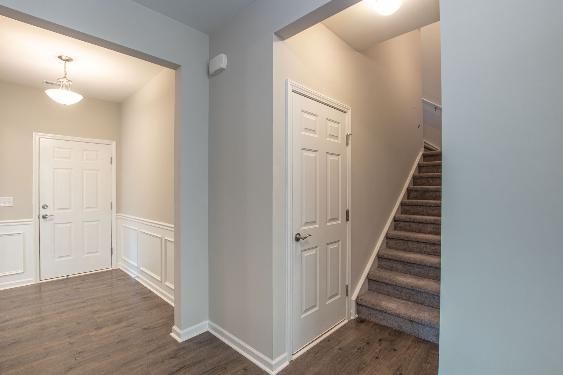 A hallway with stairs leading up to the second floor of a house.