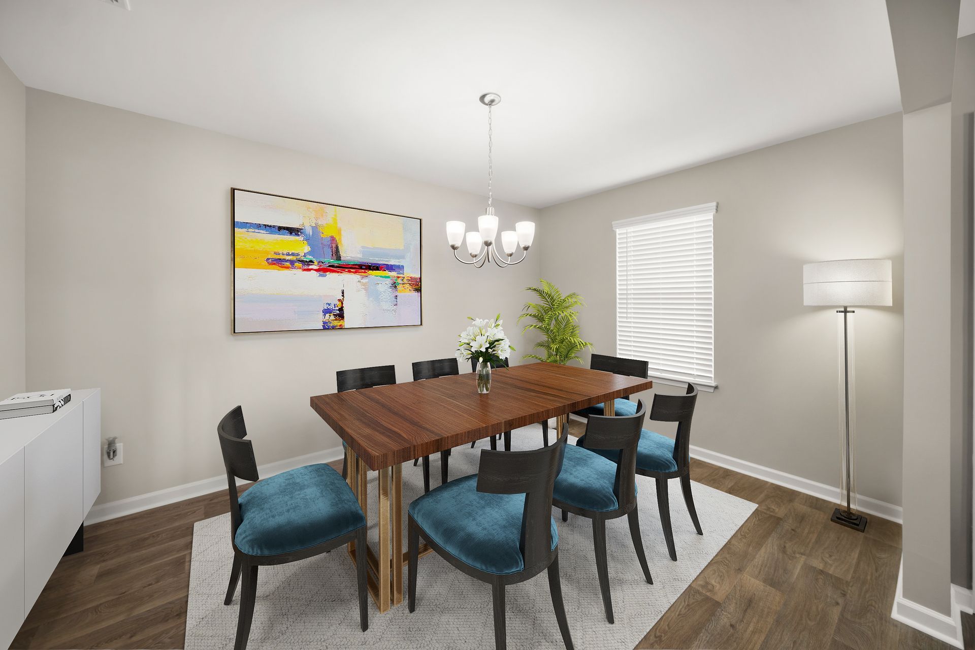 A dining room with a table and chairs and a painting on the wall.