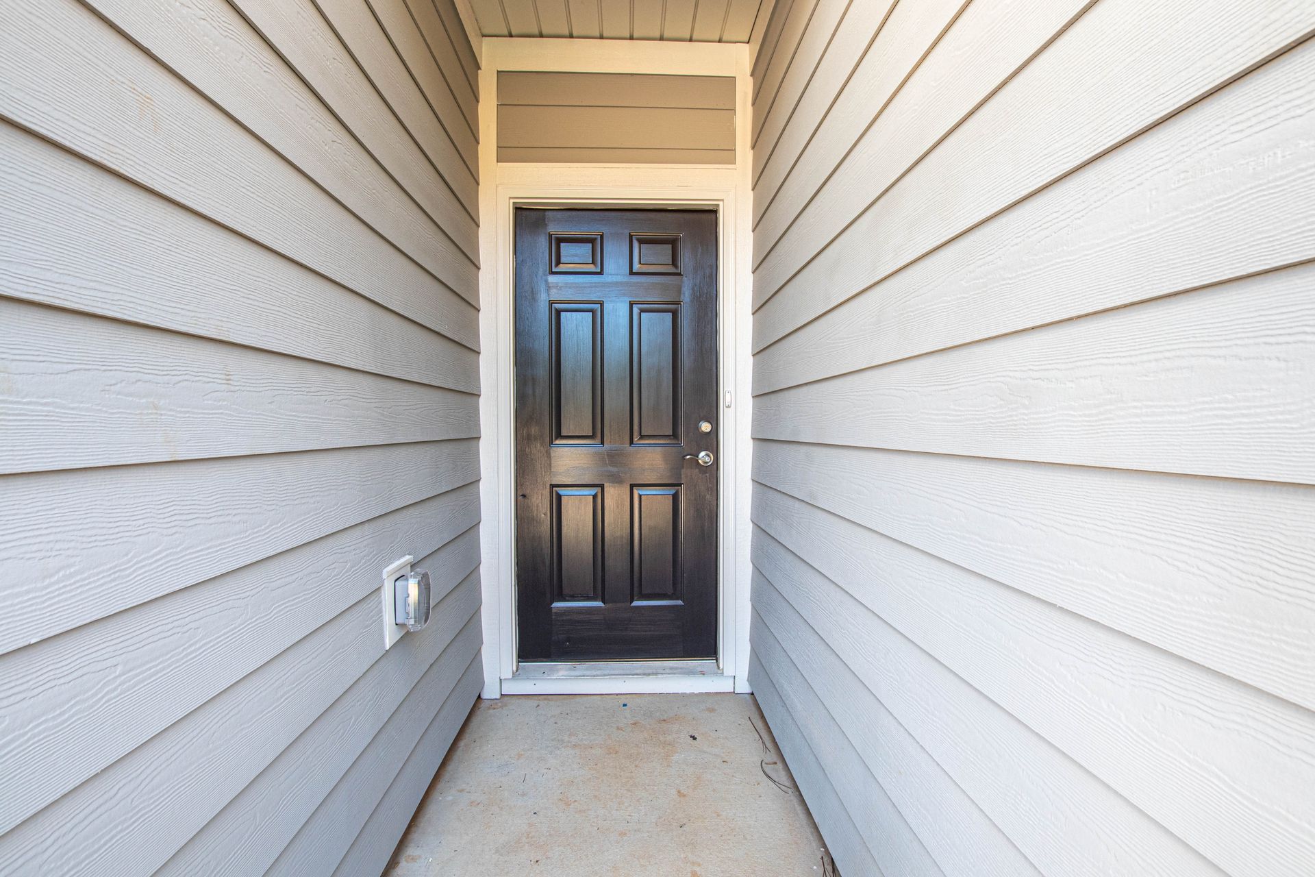 A long hallway with a black door in the middle