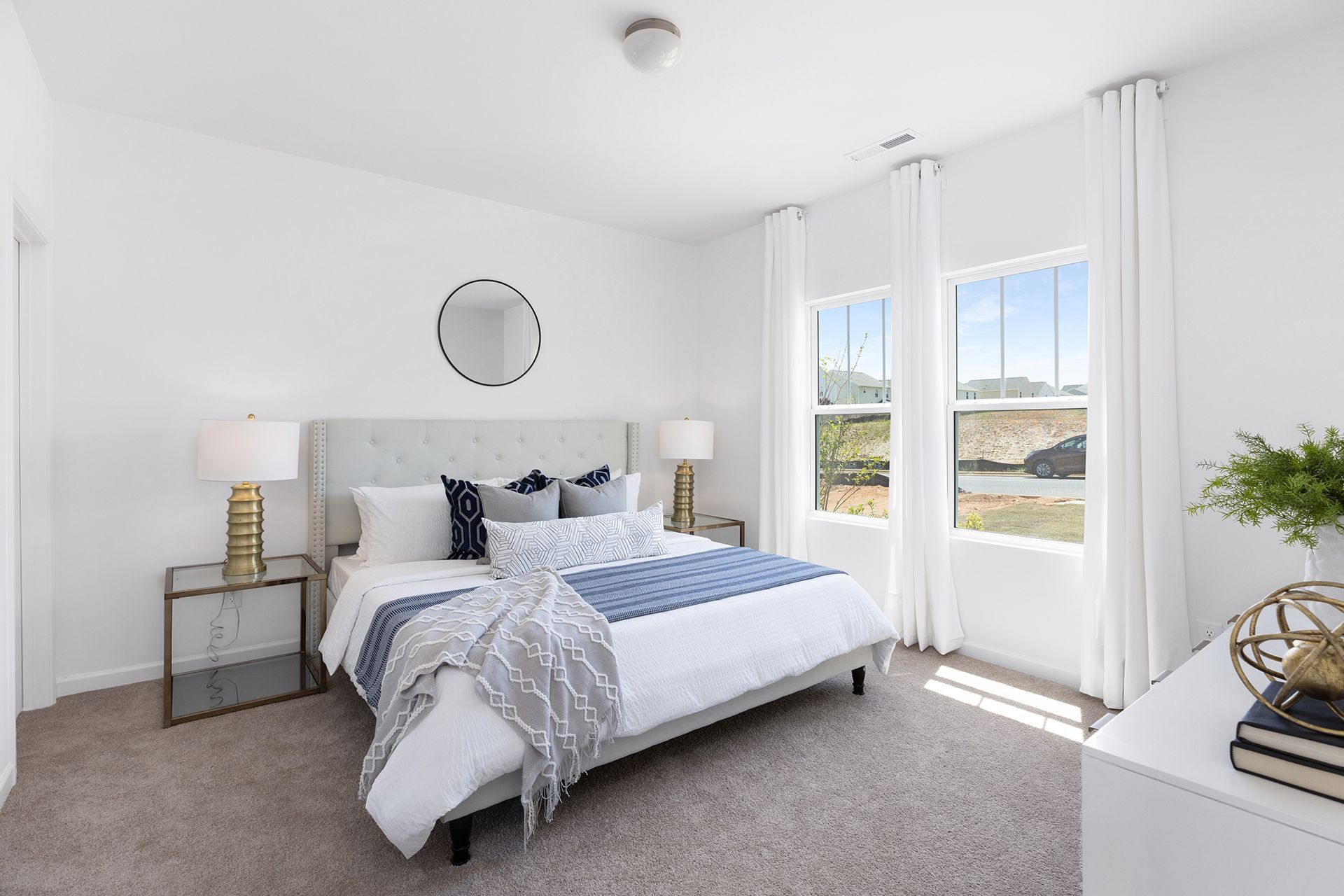 A bedroom with a large bed and two windows.