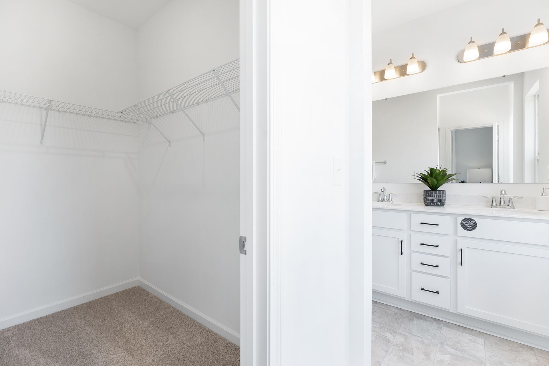 A walk in closet and a bathroom in a house.