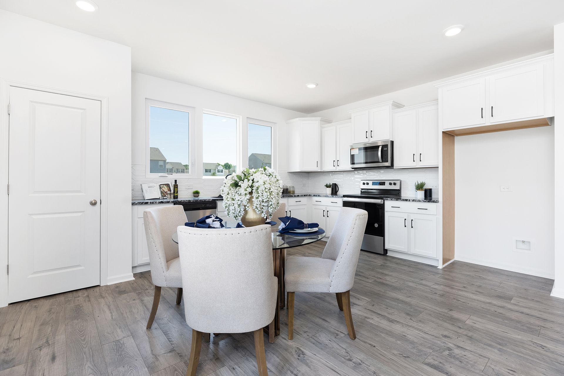 A dining room with a table and chairs in a kitchen.