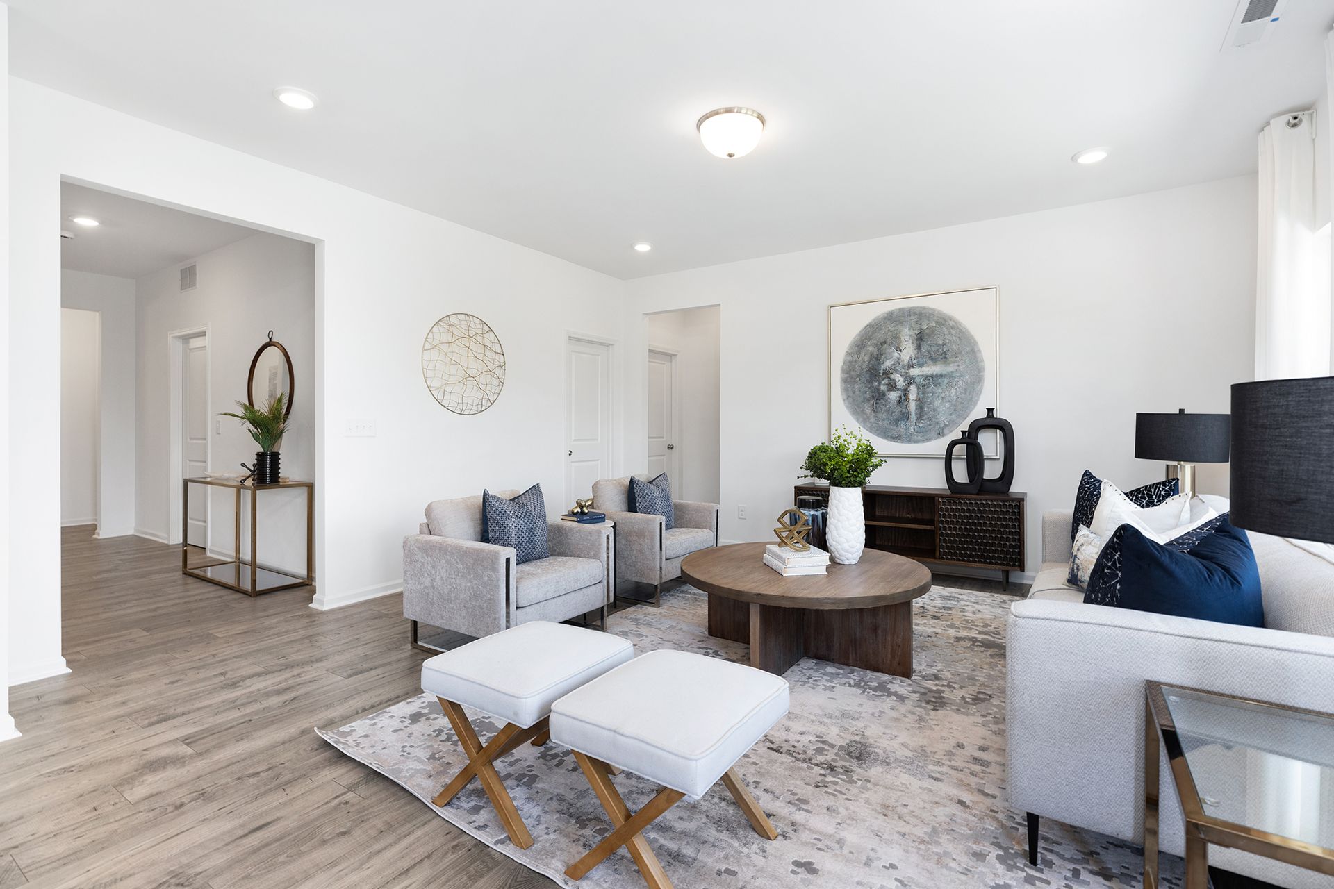 A living room with a couch , chairs , coffee table and ottomans.