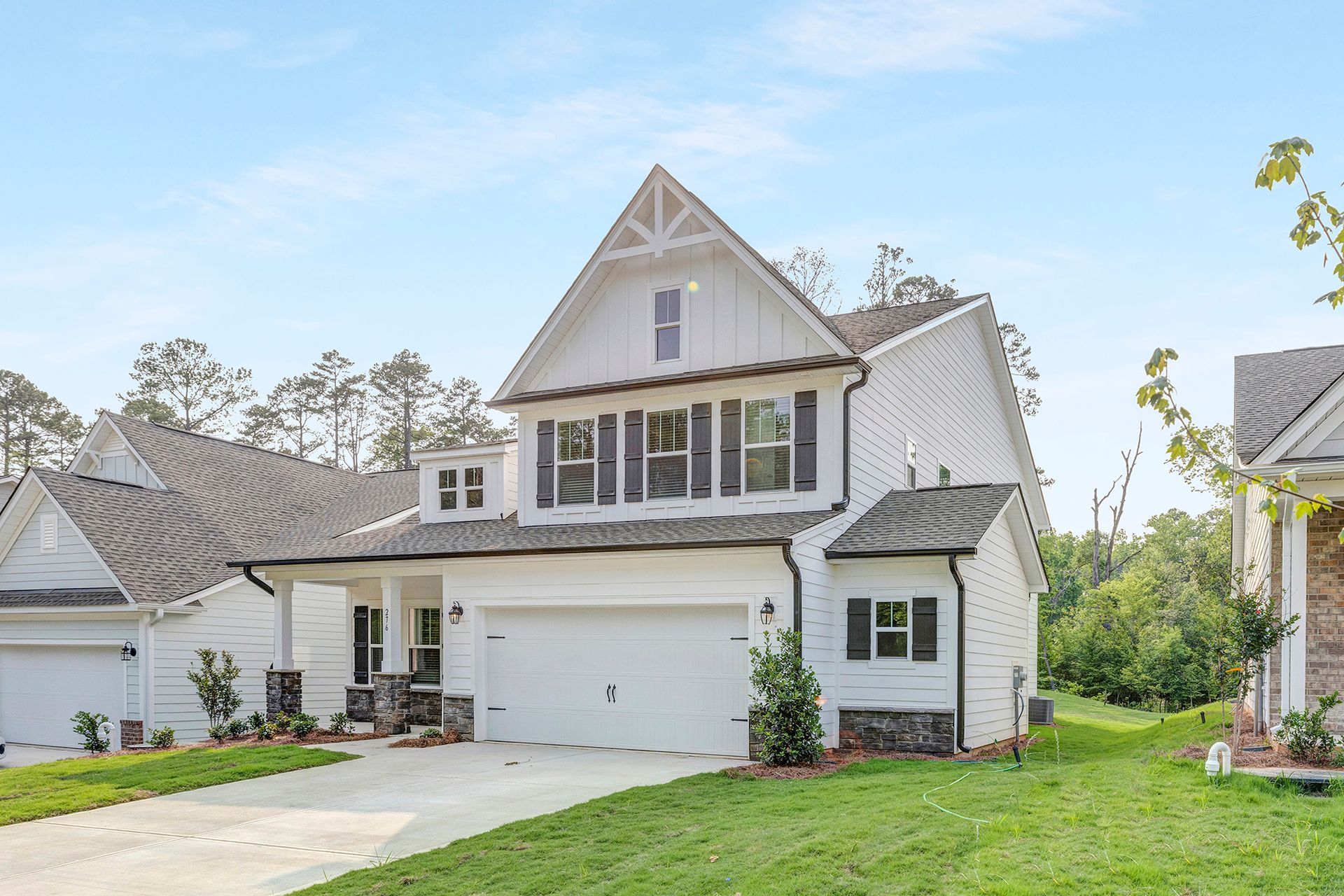 A large white house with a large garage and a driveway.