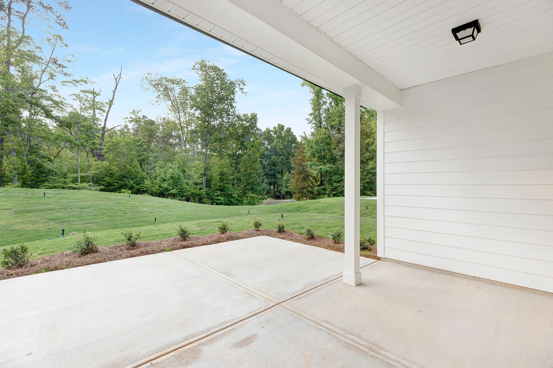 An empty patio with a view of a lush green field.
