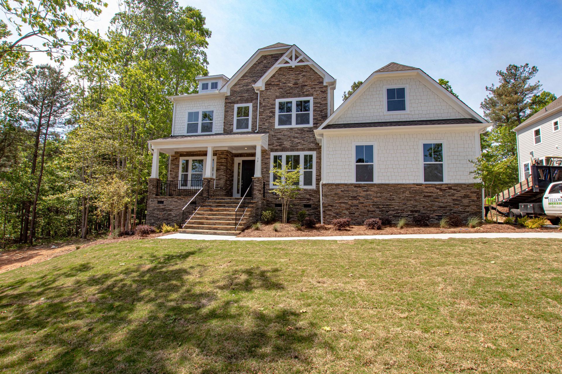 A large house with a lot of windows is sitting on top of a lush green lawn.
