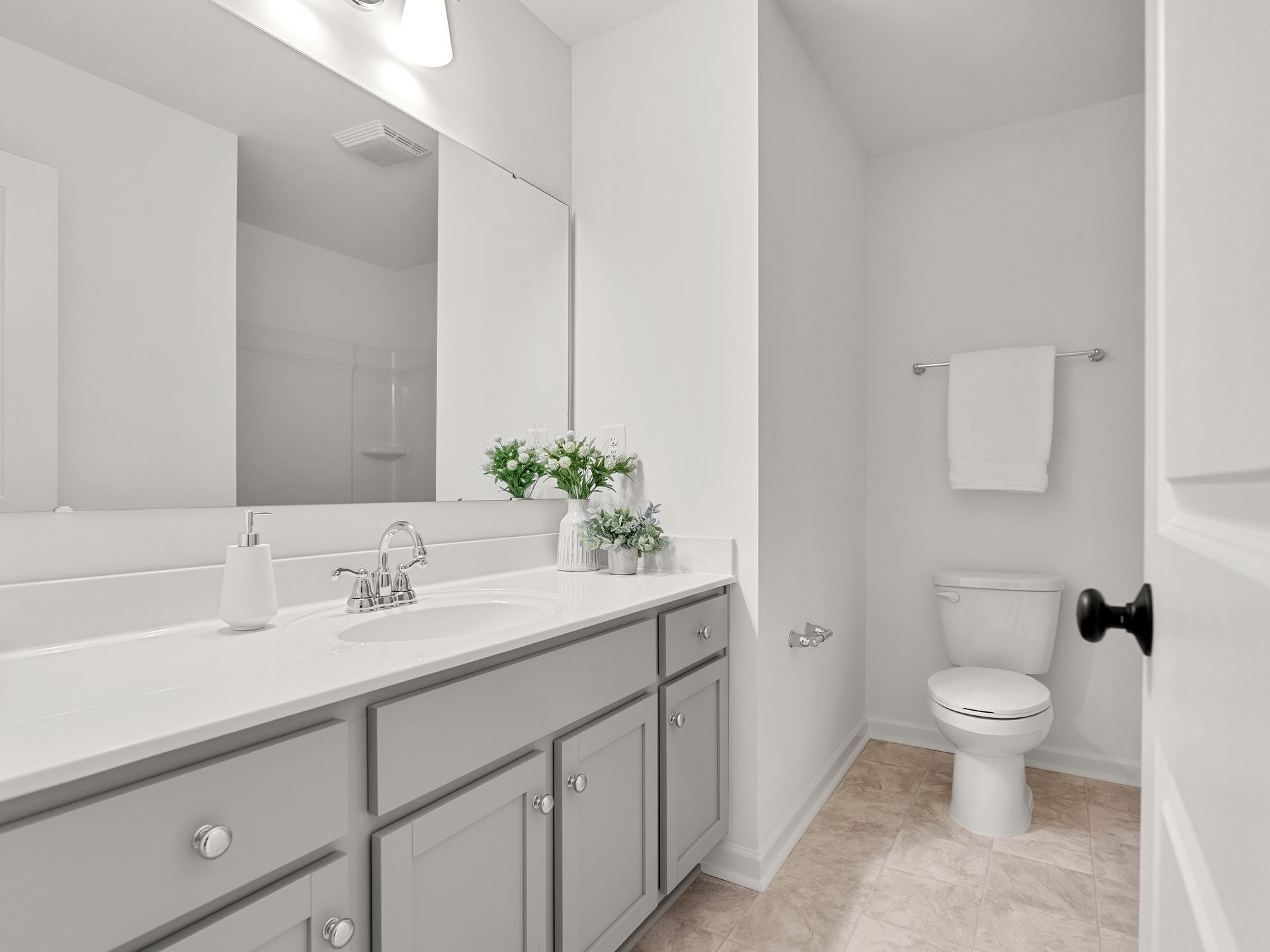 A bathroom with a sink , toilet and mirror.
