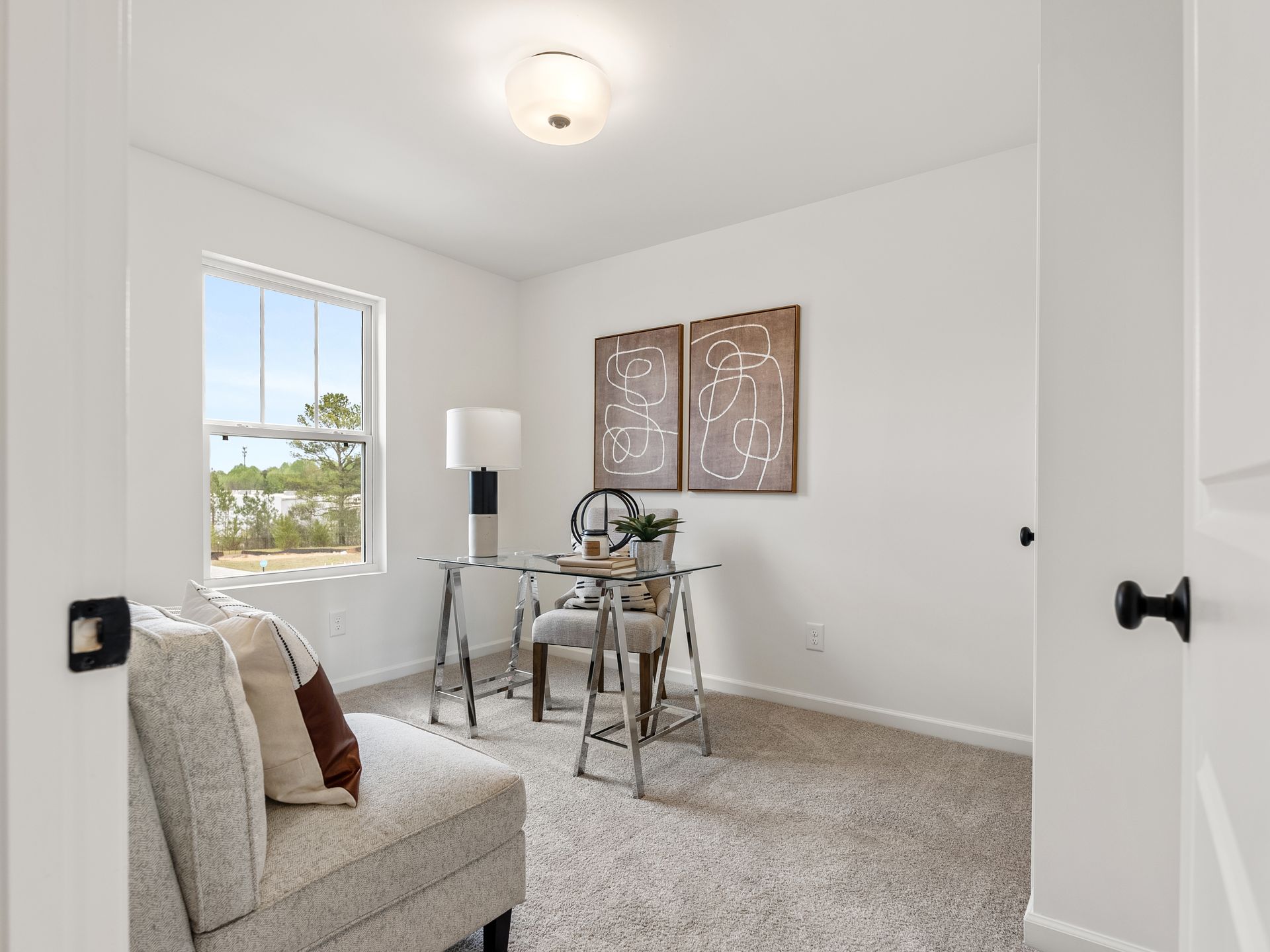 A home office with a desk , chair , and window.
