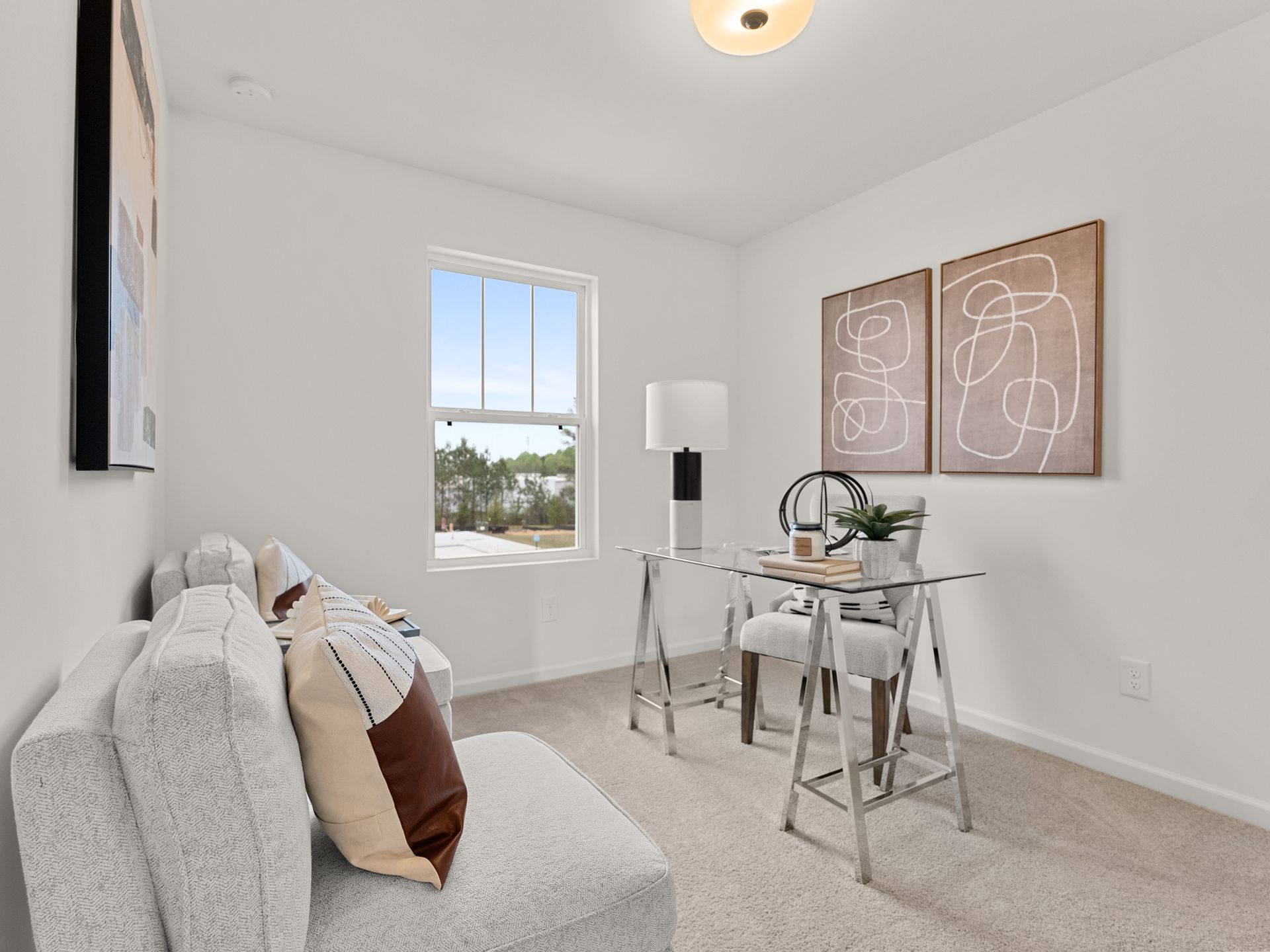 A living room with a couch , desk , chairs and a window.