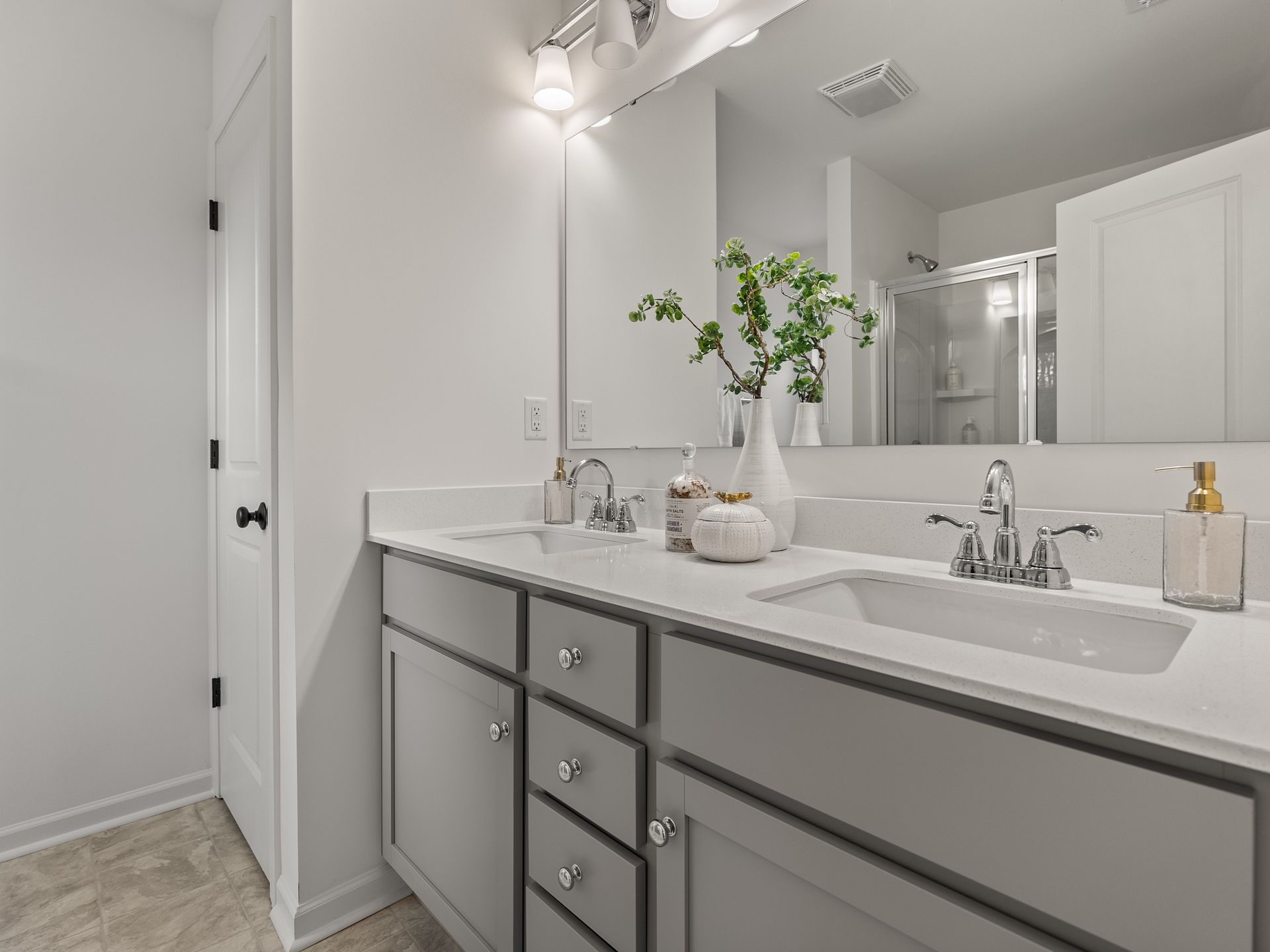 A bathroom with two sinks and a large mirror.