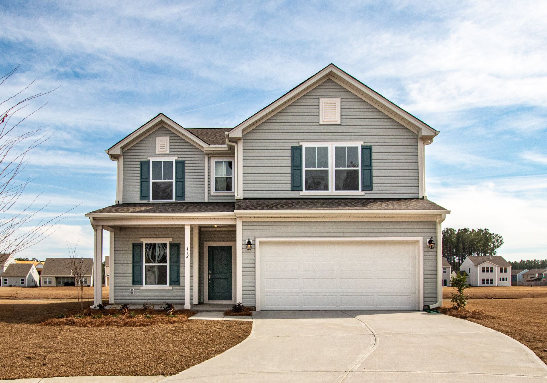 A large house with a white garage door and blue shutters