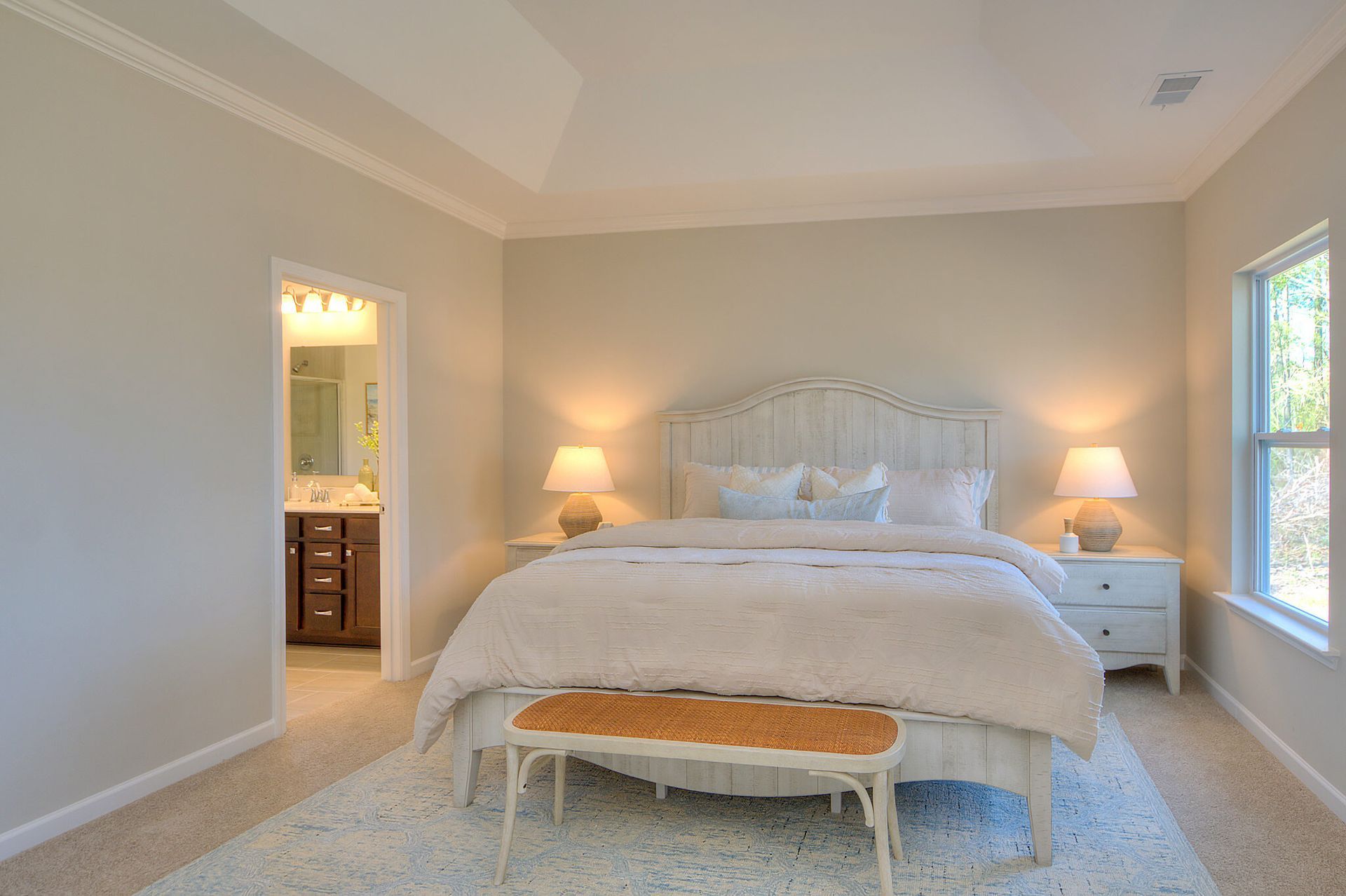 A bedroom with a king size bed and a bench.