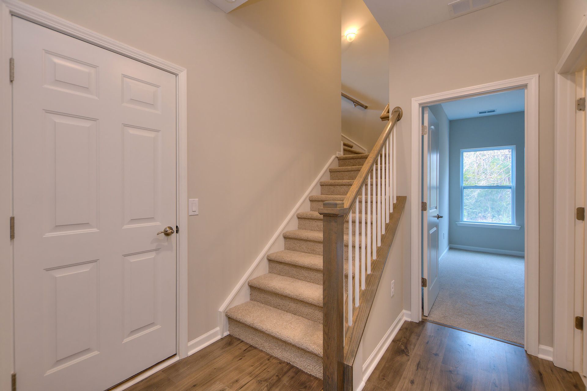 A hallway with stairs leading up to the second floor of a house.