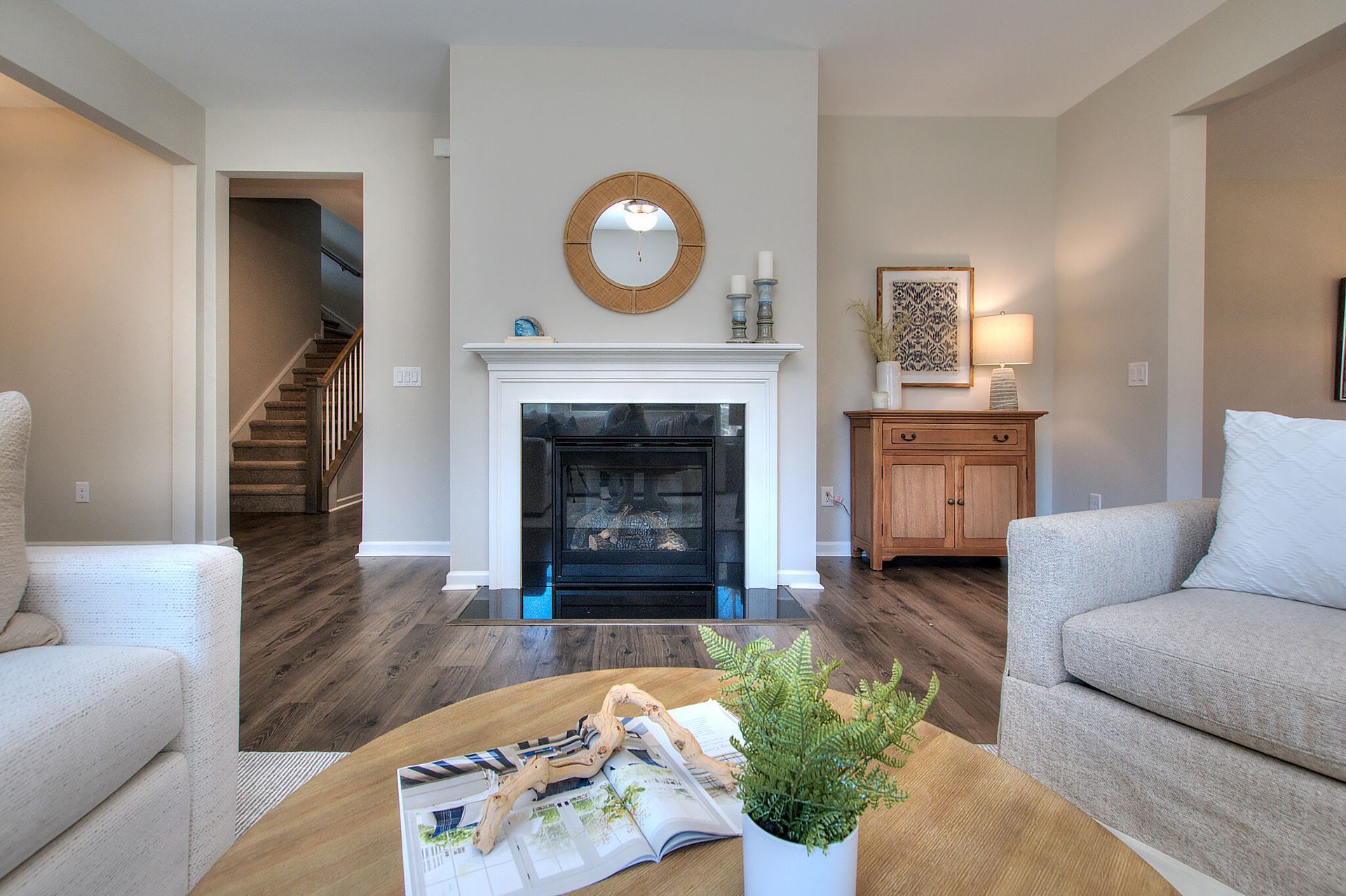 A living room with a fireplace and a round coffee table