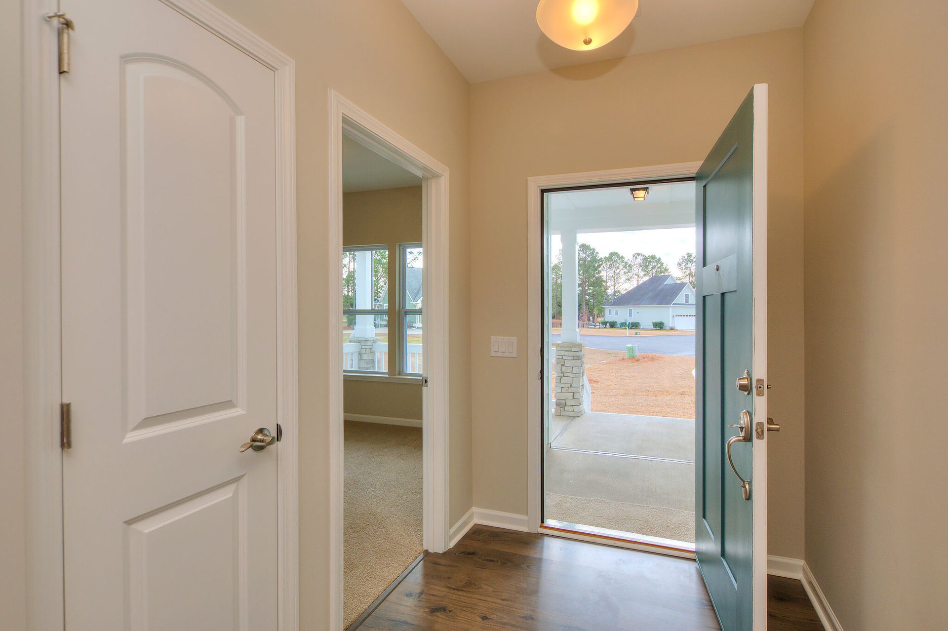 A hallway in a house with a blue door and a white door.