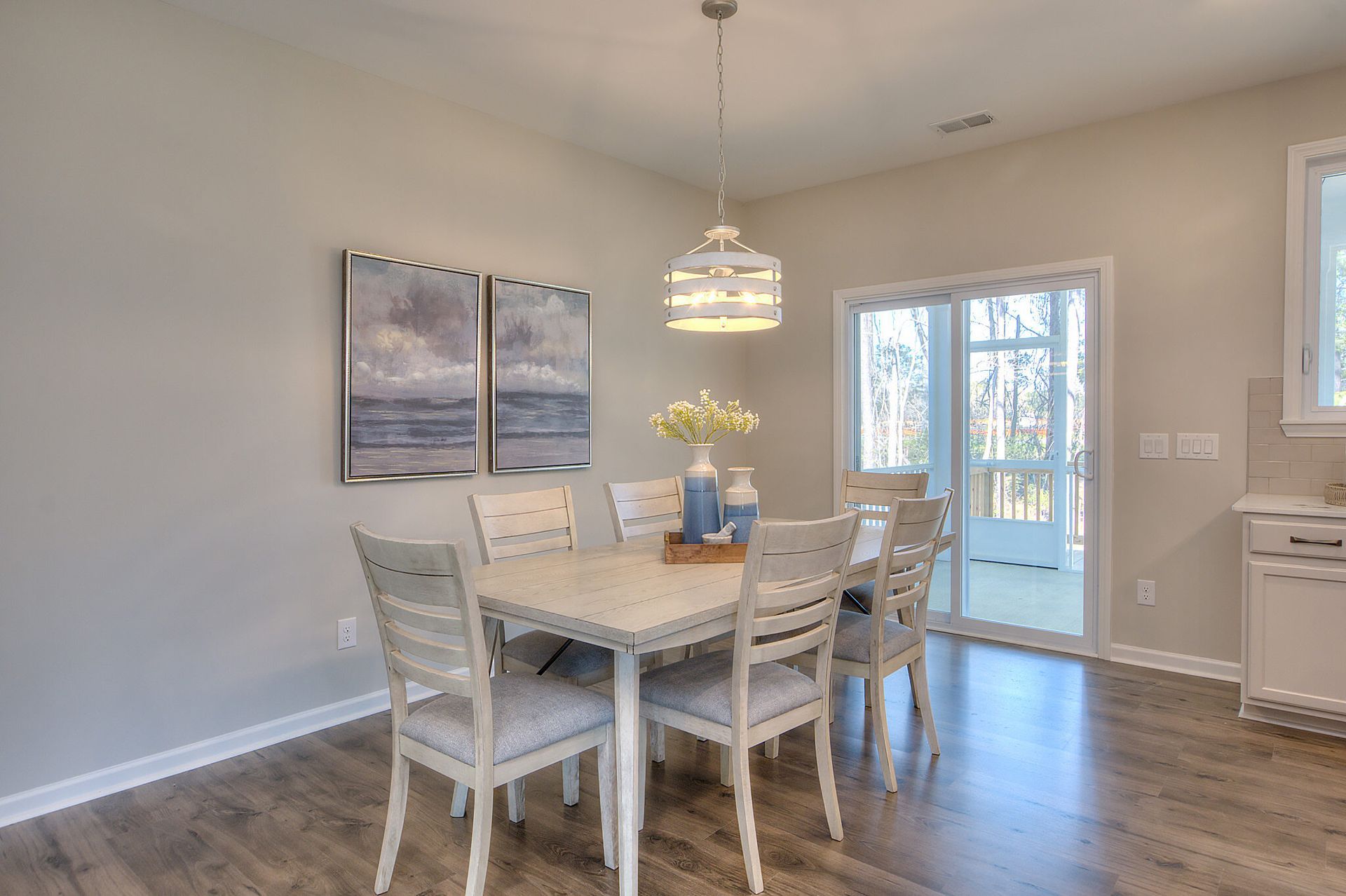 A dining room with a table and chairs and a sliding glass door.
