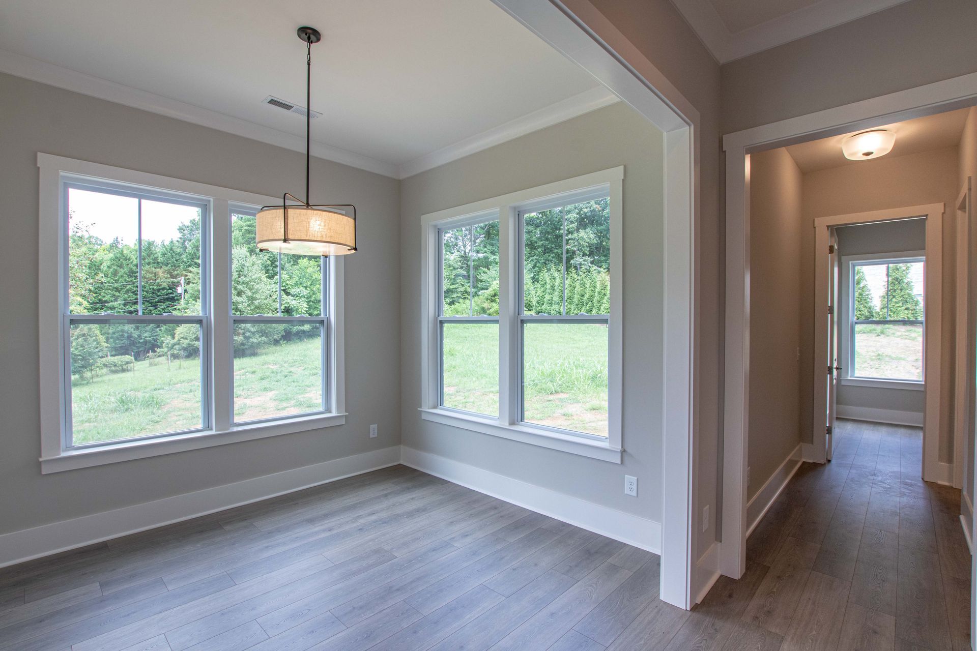 An empty room with a lot of windows and a chandelier.