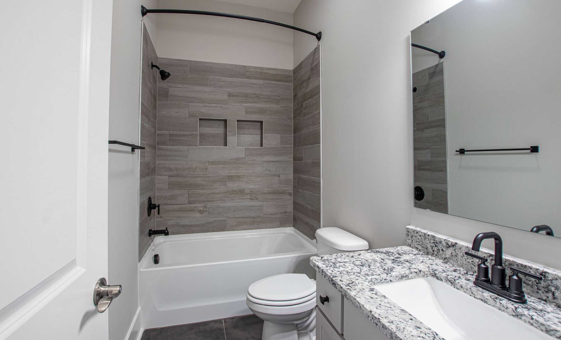 A bathroom with a toilet , sink and bathtub.