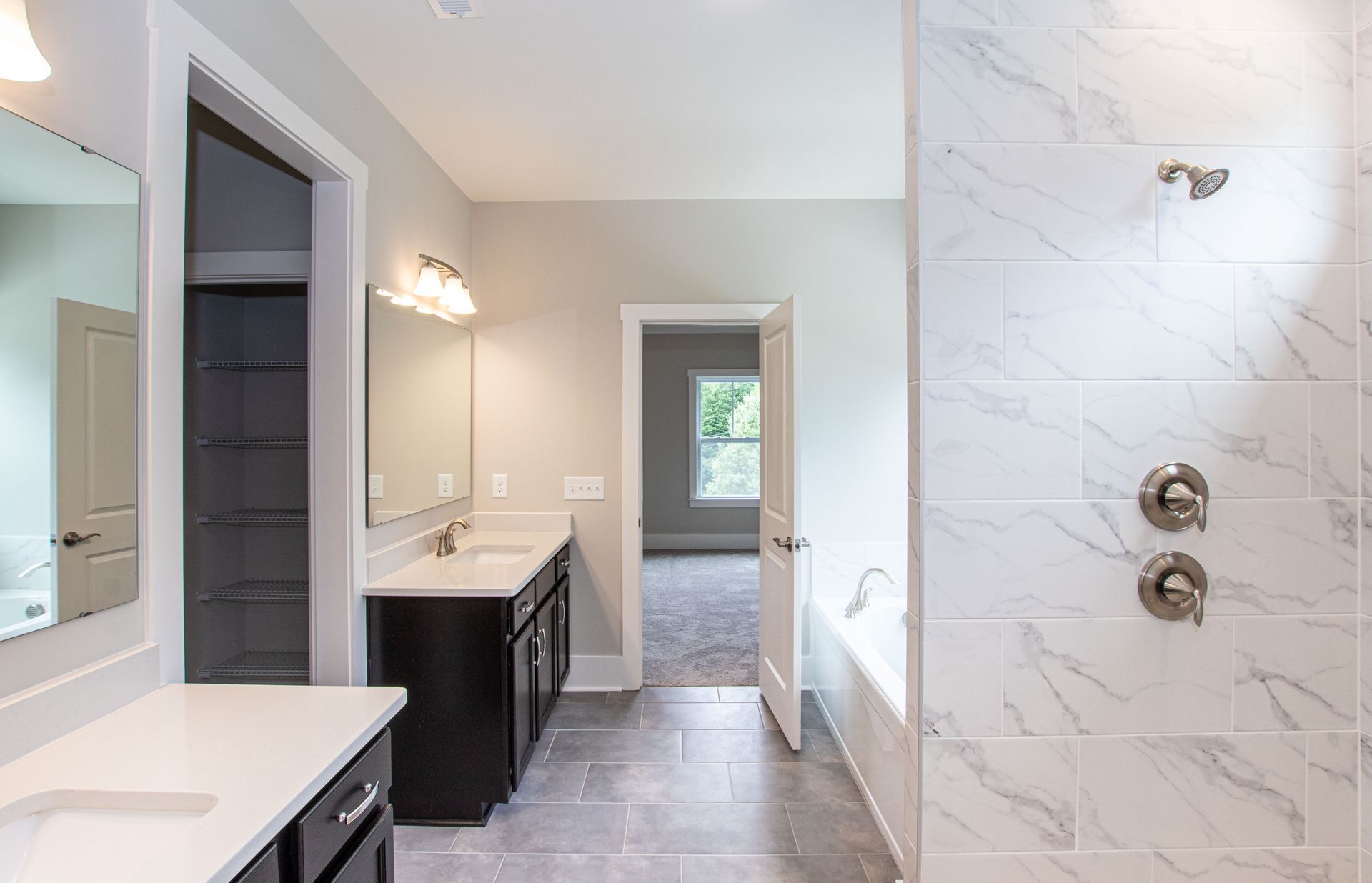 A bathroom with two sinks and a walk in shower.